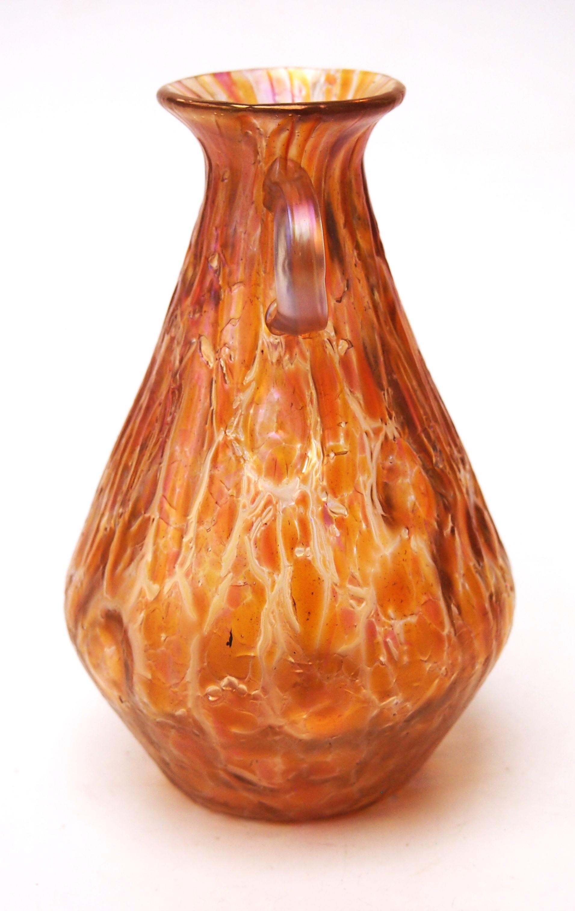 Unusual Loetz orange two handled vase in the documented pattern called Astglas. This version of the pattern Astglas has a surface covered with orange coloured craquelure of densely fused crushed glass and occasionally adorned with Silberiris coral
