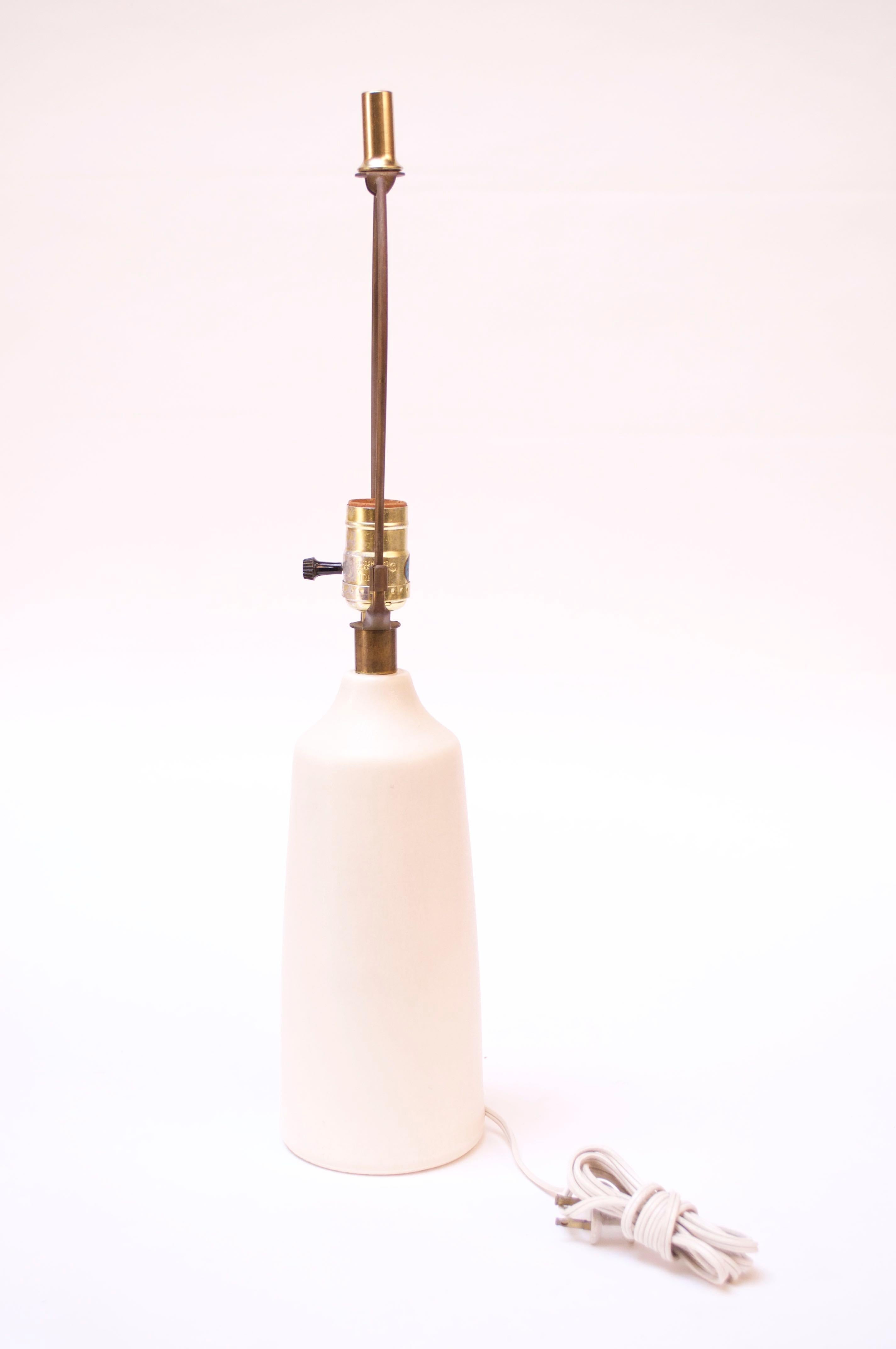 This small scale table lamp was designed and manufactured in the 1960s by Lotte and Gunnar Bostlund after they relocated their ceramic studio from Denmark to Canada. The applied, unpolished brass neck with warm patina adds a rich contrast to the