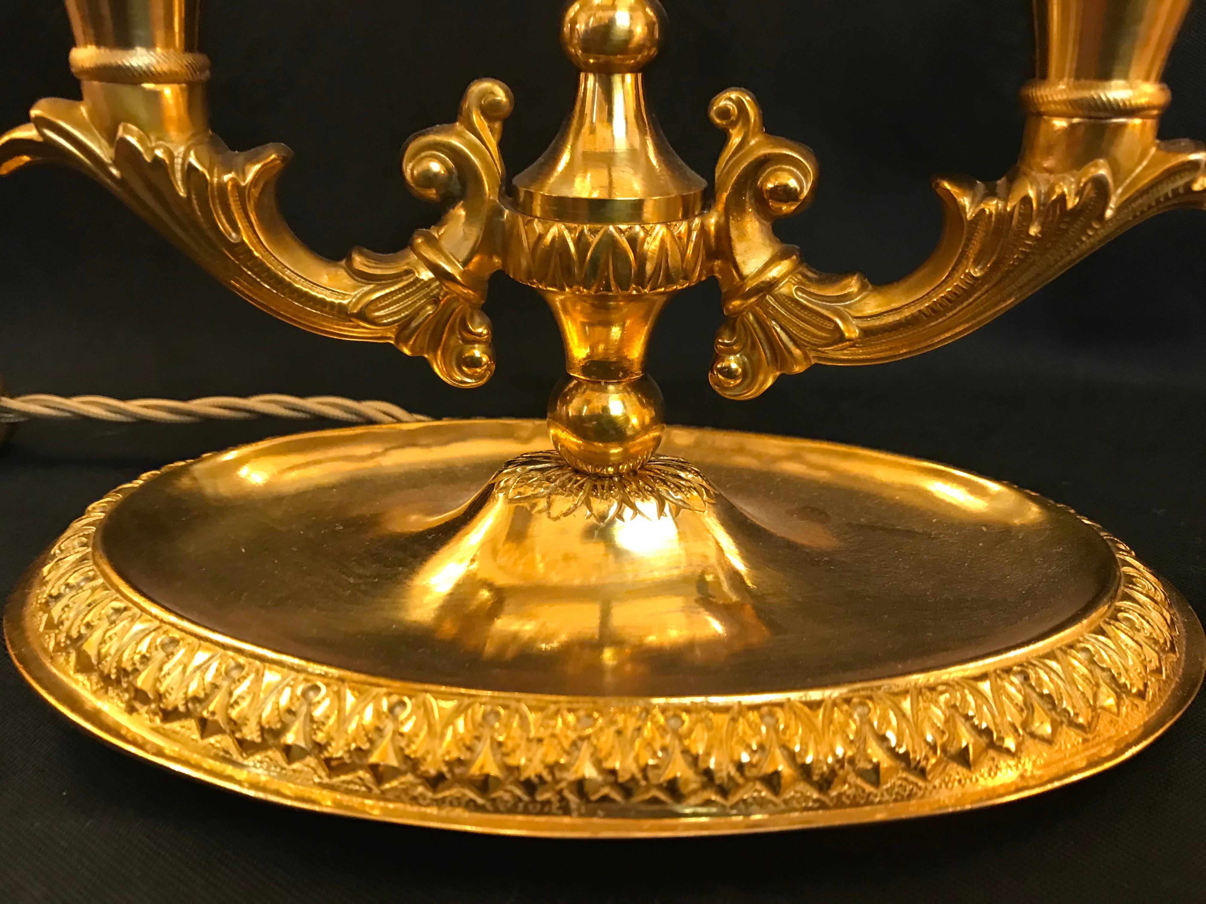 Diese feine und elegante Bouillotte im Louis XVI-Stil aus vergoldeter Bronze und handbemaltem Zinn von Gherardo Degli Albizzi verfügt über zwei Lichter. Der Toleware-Schirm ist mit grüner Emaille und goldenen Feder- und Pflanzendekorationen