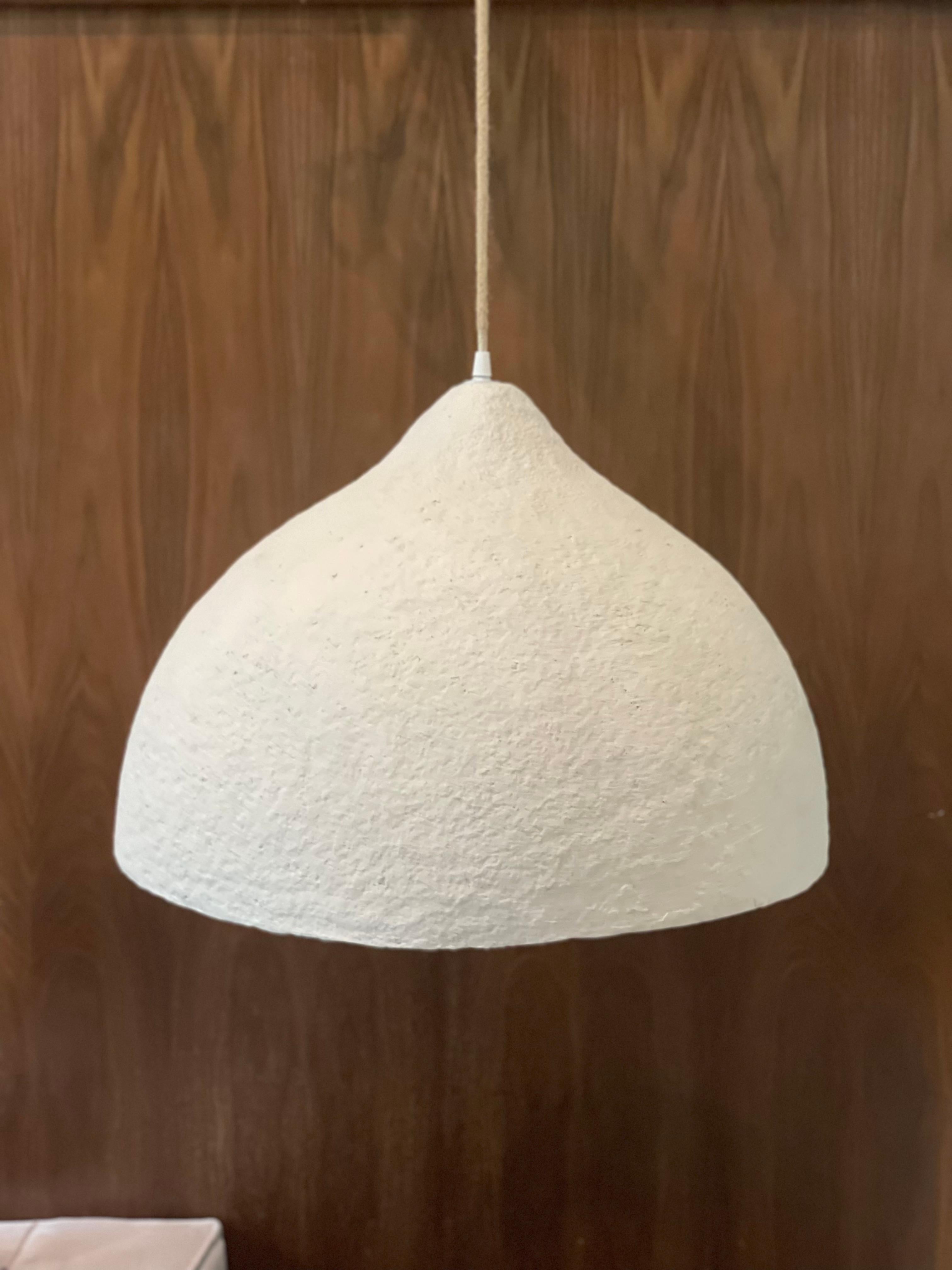 Lampada a sospensione Luna Small di Ana Tron
Fatto a mano
Dimensioni: D. 35 x H. 30 cm
Materiali: Carta riciclata con pasta, gesso e vernice opaca a base d'acqua. Rivestimento interno in resina epossidica ecologica.
Disponibile in nero, grigio