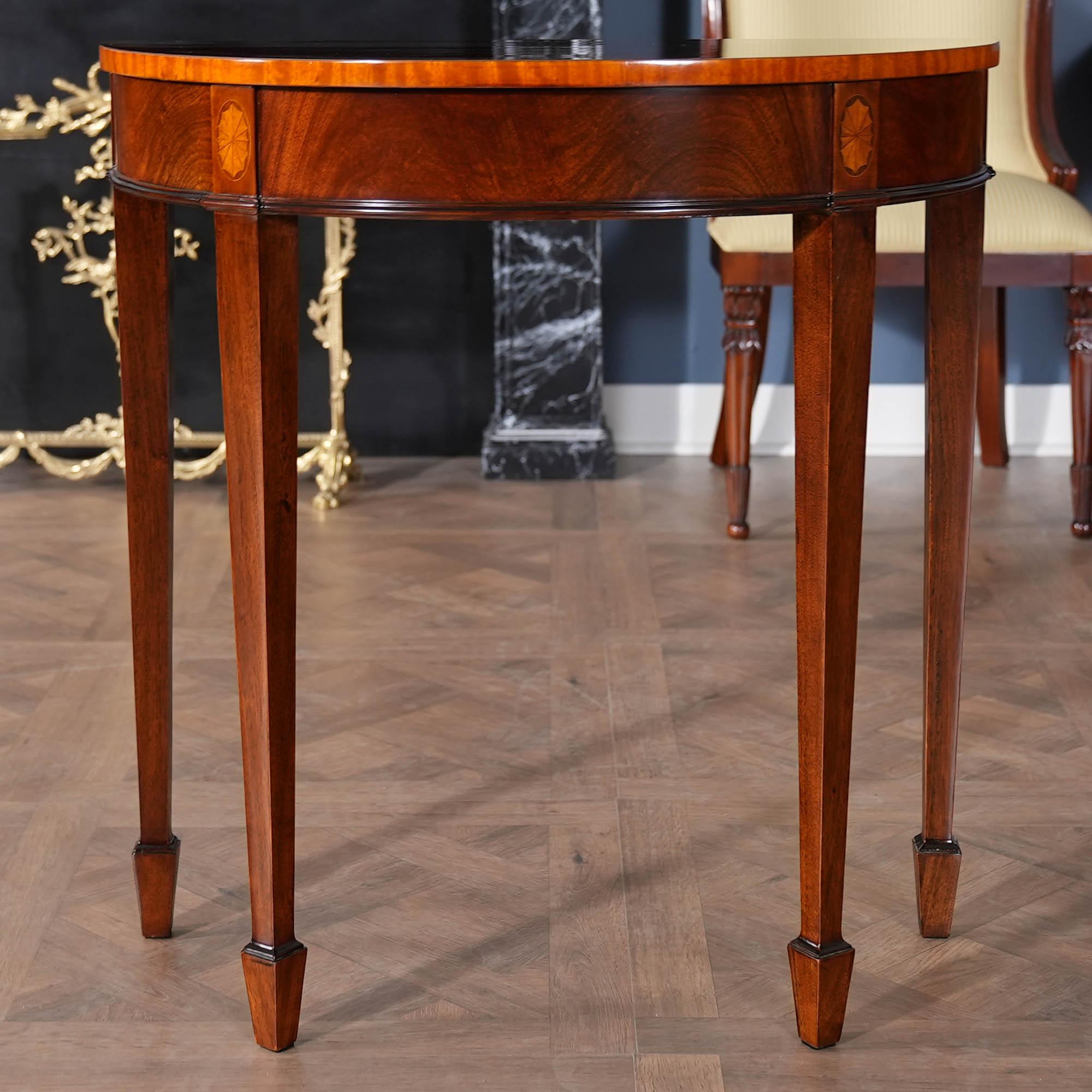 A high quality Small Mahogany Banded Console table from Niagara Furniture which makes elaborate use of hand cut inlays. The mahogany top is banded with satinwood, the four legs at the apron have oval fan shaped inlays and the legs themselves are