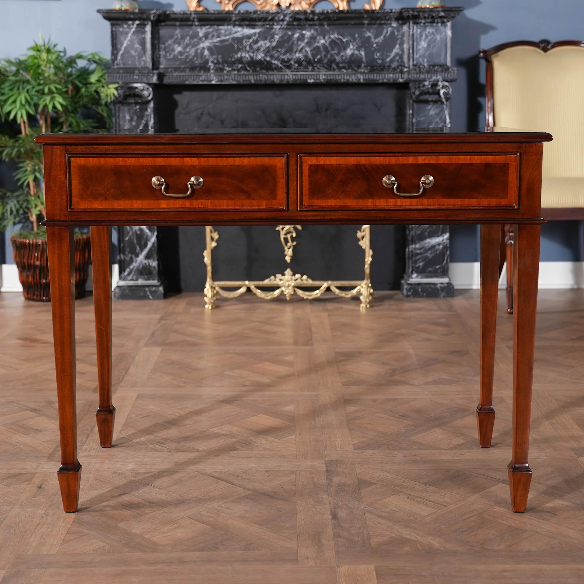 A high quality Small Mahogany Banded Desk from Niagara Furniture made of mahogany and satinwood with solid brass drawer pulls. The two dovetailed drawers denote high quality construction and the elegant tapered legs end in a popular spade foot