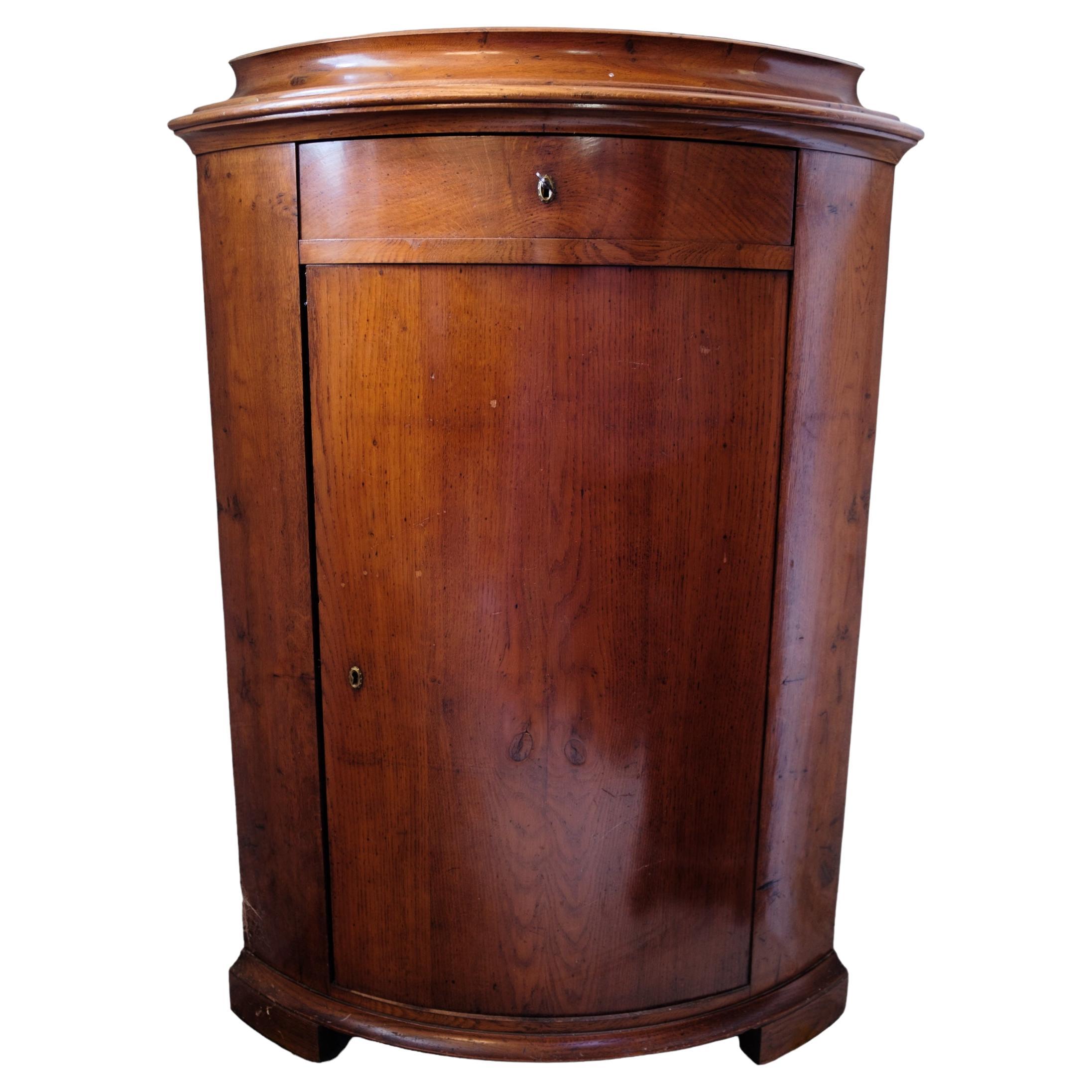 Small mahogany corner cabinet with door and drawer from around the 1880s