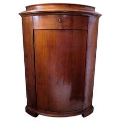 Small mahogany corner cabinet with door and drawer from around the 1880s