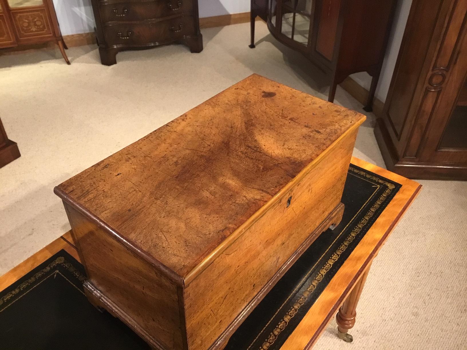 A small mahogany early 18th century antique box. Having a rectangular top of beautiful color and patination which opens to reveal a small storage area. The front with exposed dove tails indicating this may be an apprentice piece. With mahogany sides