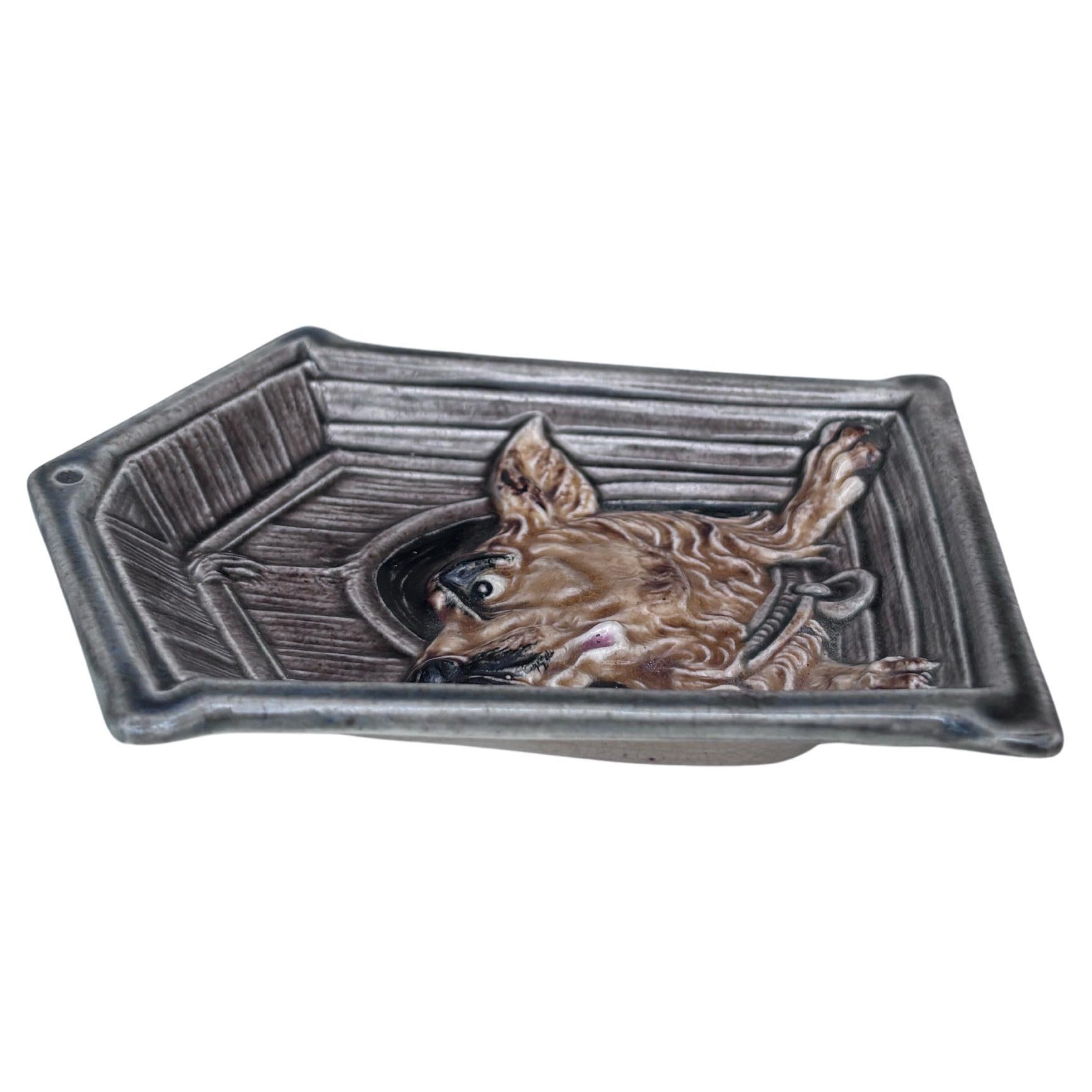 Piccolo vassoio in maiolica con cane in una cuccia.
5 per 3,8 pollici.