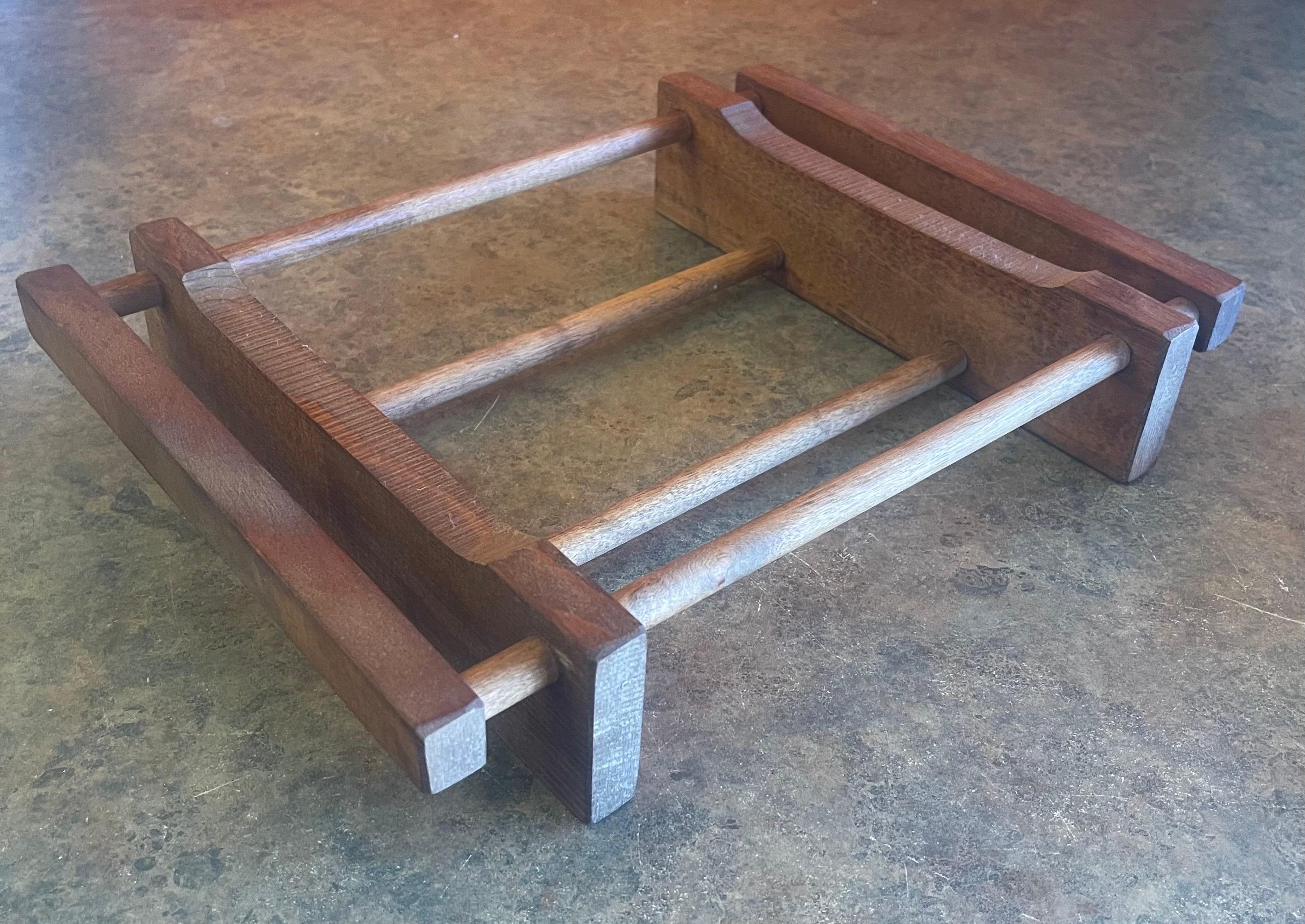 Small MCM solid wood trivet designed to hold a square casserole dish, circa 1970s.  The piece is made of wood, is in very good vintage condition and measures 13.5