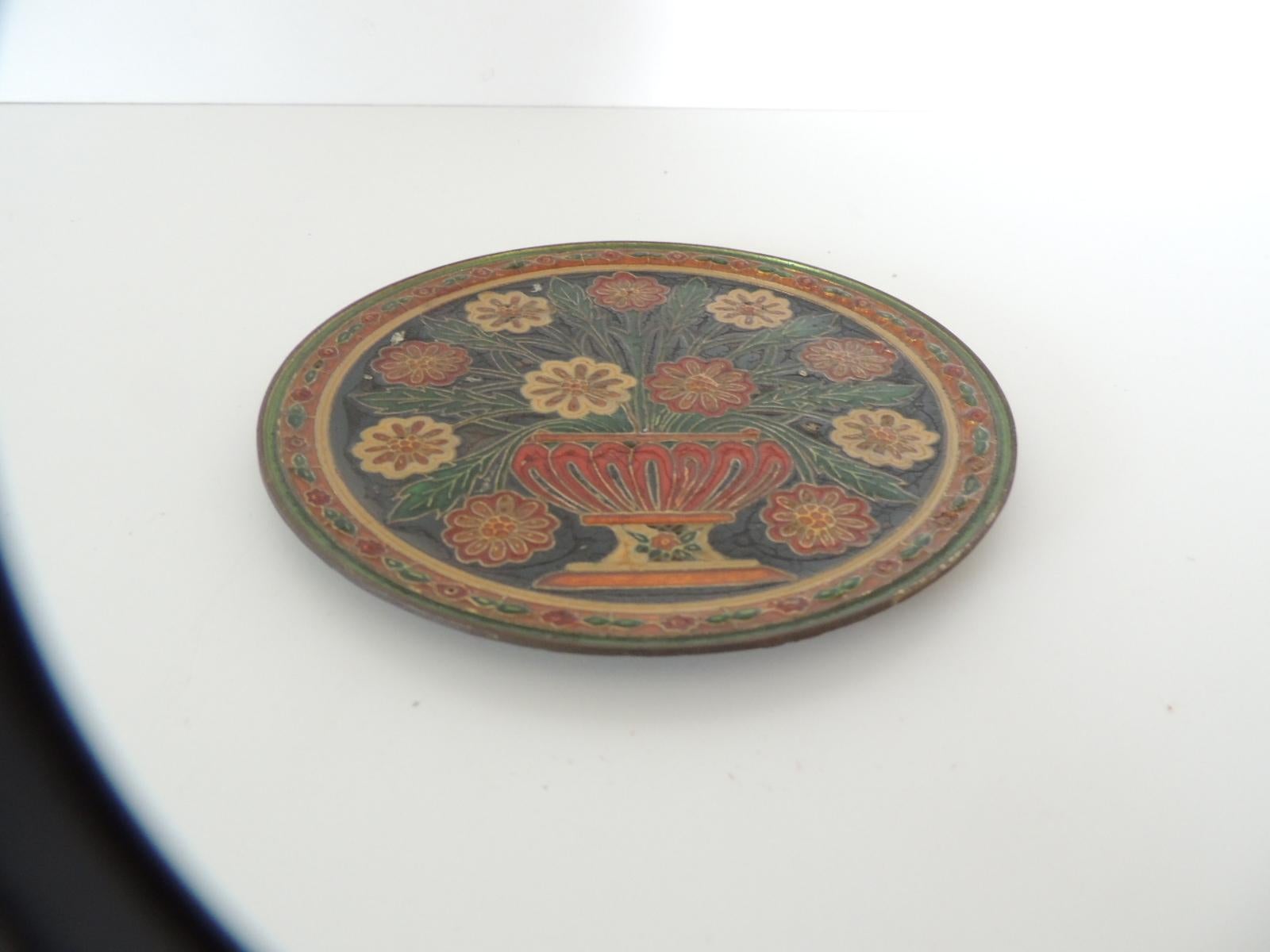 Small metal cloisonné hand painted decorative wall plate.
Depicting urn with blooming flowers in shades of red, yellow, green and black.
Hanging hook in the back.
Size: 6