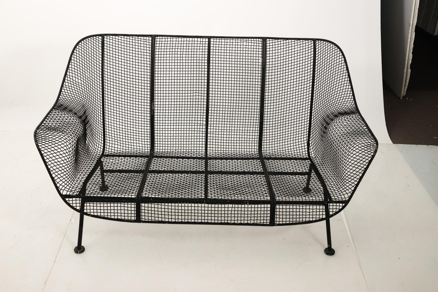 Small black metal garden or outdoor settee by Russell Woodard in the style of Sculptura with molded seat. Please note of wear consistent with age.