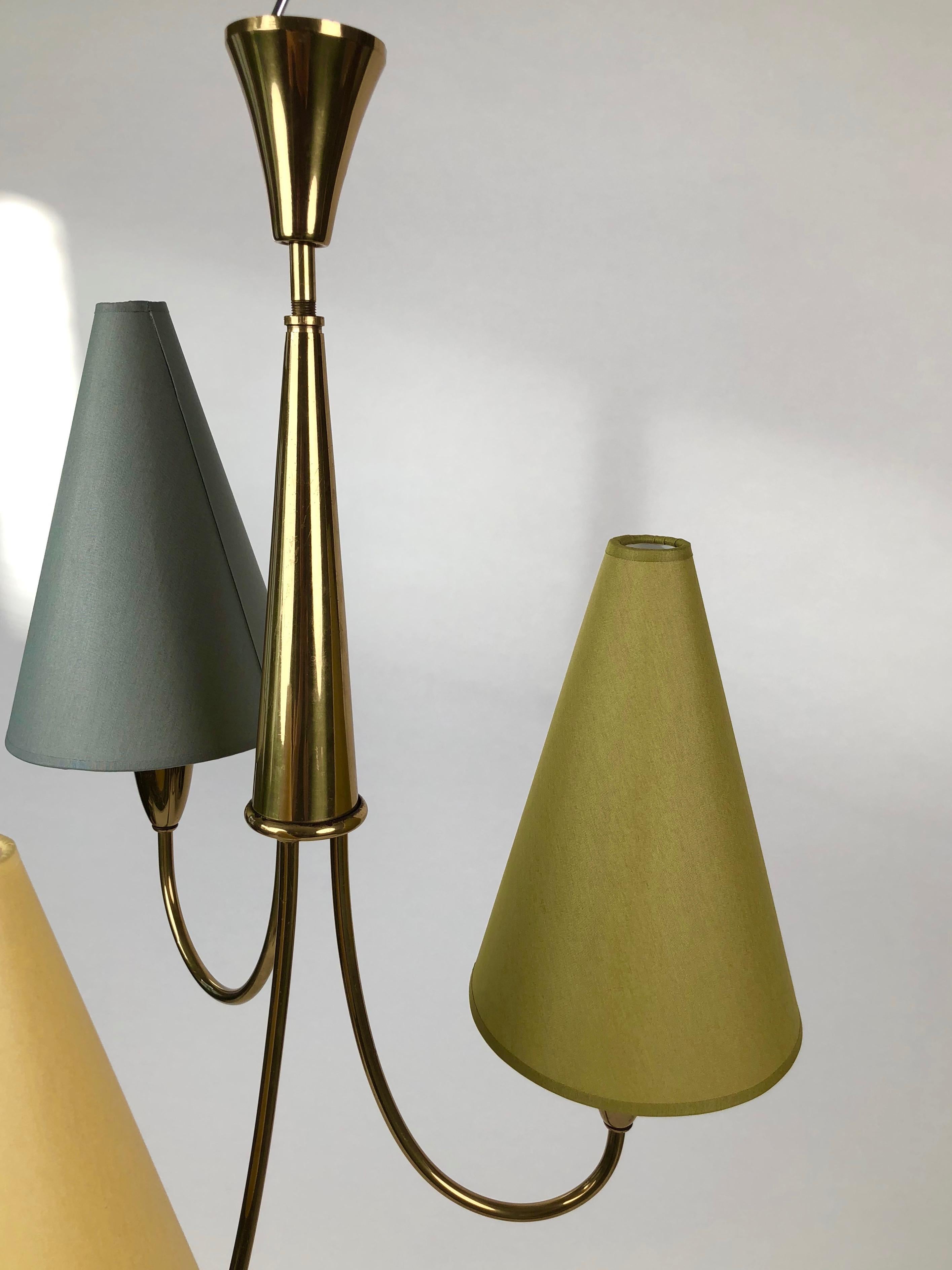 Lovely midcentury pendant lamp made in solid brass with cone shades that complement the shapes in the lamp.
The shades are new and has been rewired.