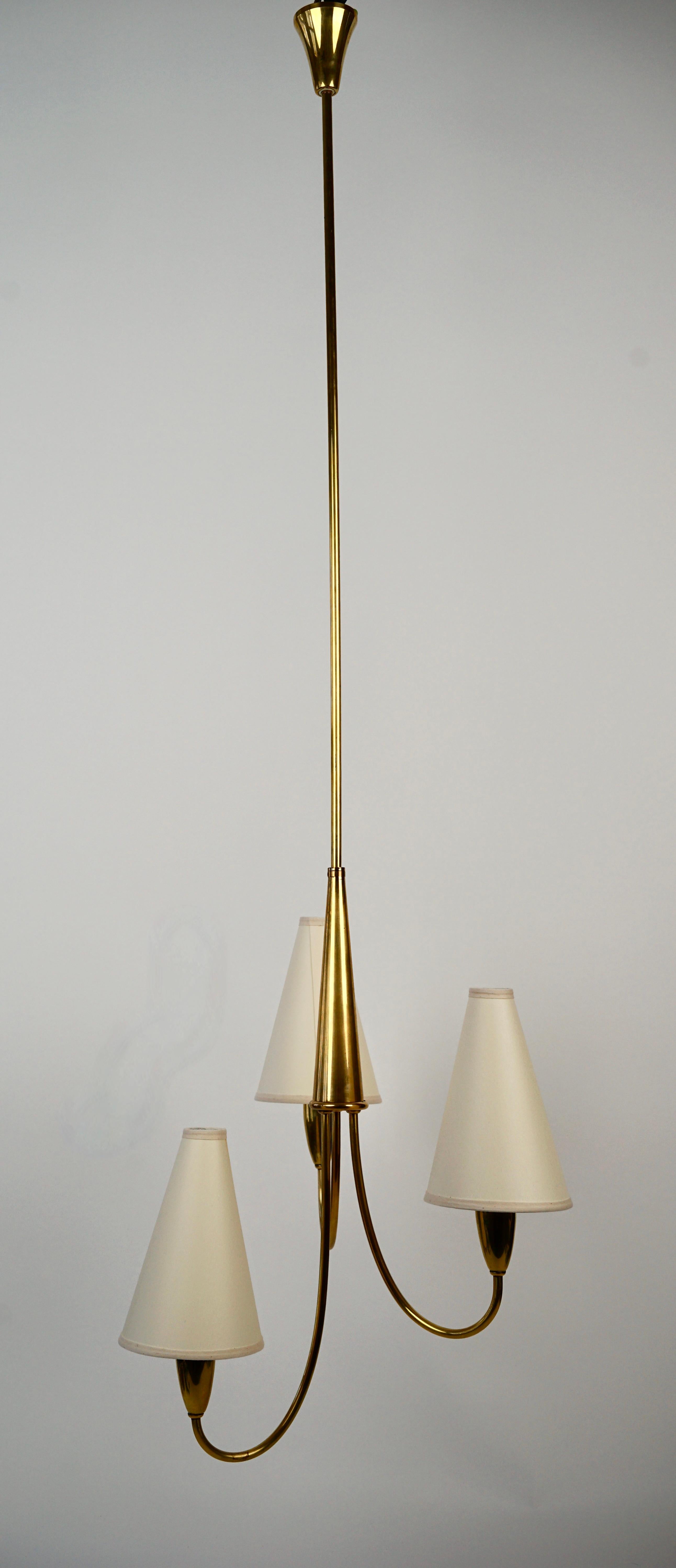 An elegant midcentury pendant lamp in brass with paper shades from Rupert Nikoll, 
hand made in Austria.

The three shades have been made new in light cream paper, using the original dimensions .

The length of the tube can be made smaller or in two