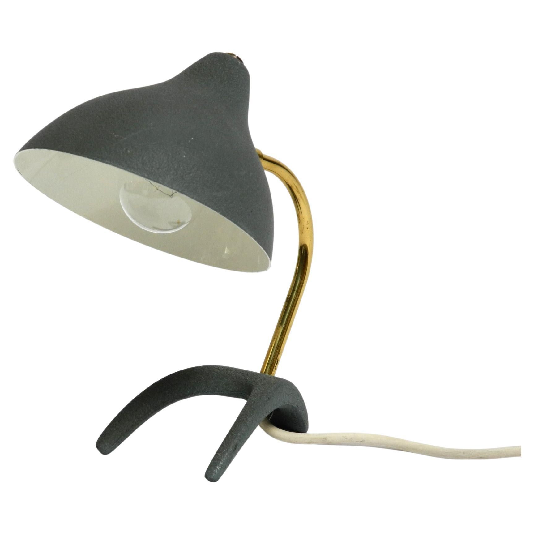 Very nice Mid Century Modern crow's foot table lamp in very good original condition.
Design by Louis Kalff. Beautiful design with a movable lampshade.
Painted in gray green by using the shrink paint process.
Aluminum lampshade, brass neck and metal