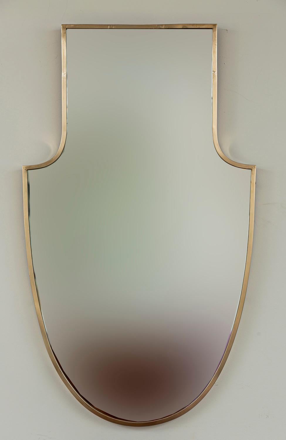 Affascinante e scenografica specchiera neoclassica a forma di scudo ispirata a Gio Ponti degli anni '30 e '40.  Questa forma e scala è splendidamente rifinita con un ottone lucido non laccato e un retro in legno.

Ottone non laccato, lucidato di