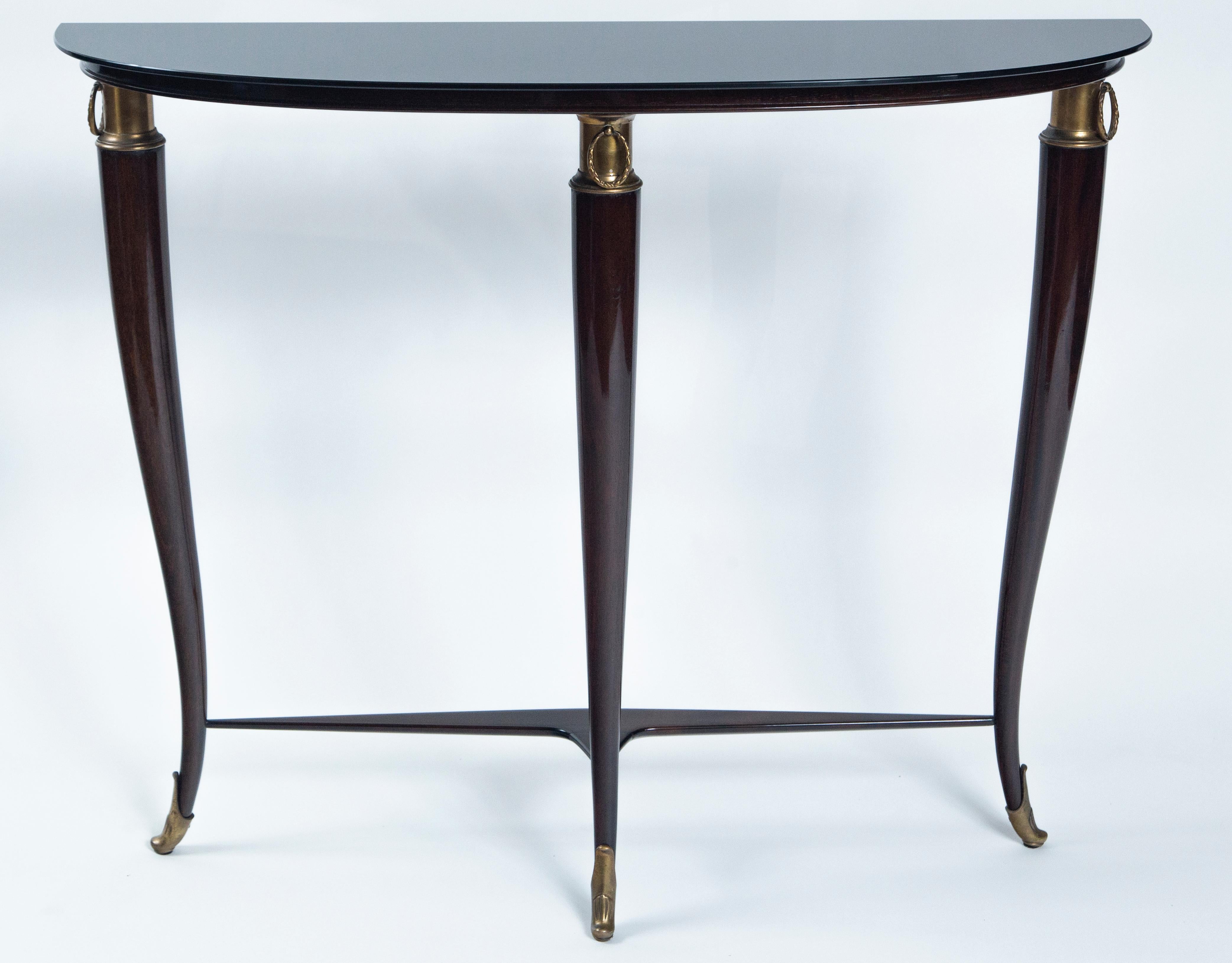 Fabulous demilune shaped console table with new black glass top over a solid mahogany base with brass ring fittings and sabots by Paola Buffa
free standing but necessary to attach to the wall for proper stability
Date: circa 1940
Origin: