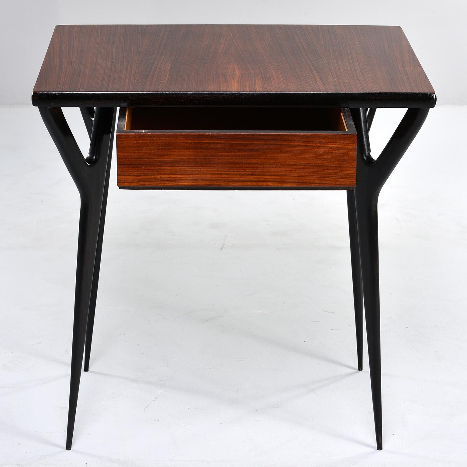 Italian desk or writing table has wishbone style tapered ebonised legs and side supports and contrasting wood top with single centre drawer, circa early 1960s. Measures: Knee height is 25.75