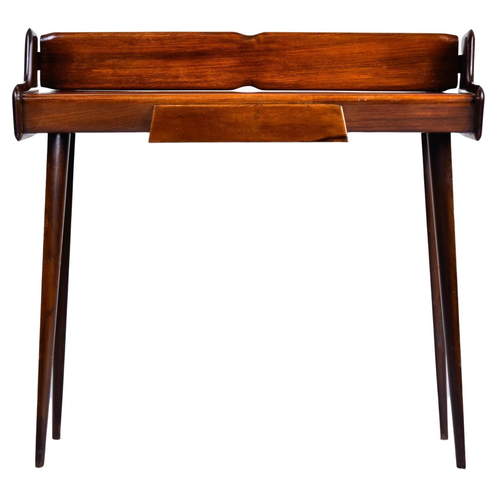 Found in Italy, this small console dates from the early 1960s or late 1950s. Made of mahogany with a medium stained finish. Single functional drawer, tapered legs and an unusual shape, this piece is very versatile. Unknown maker.

Top Surface: