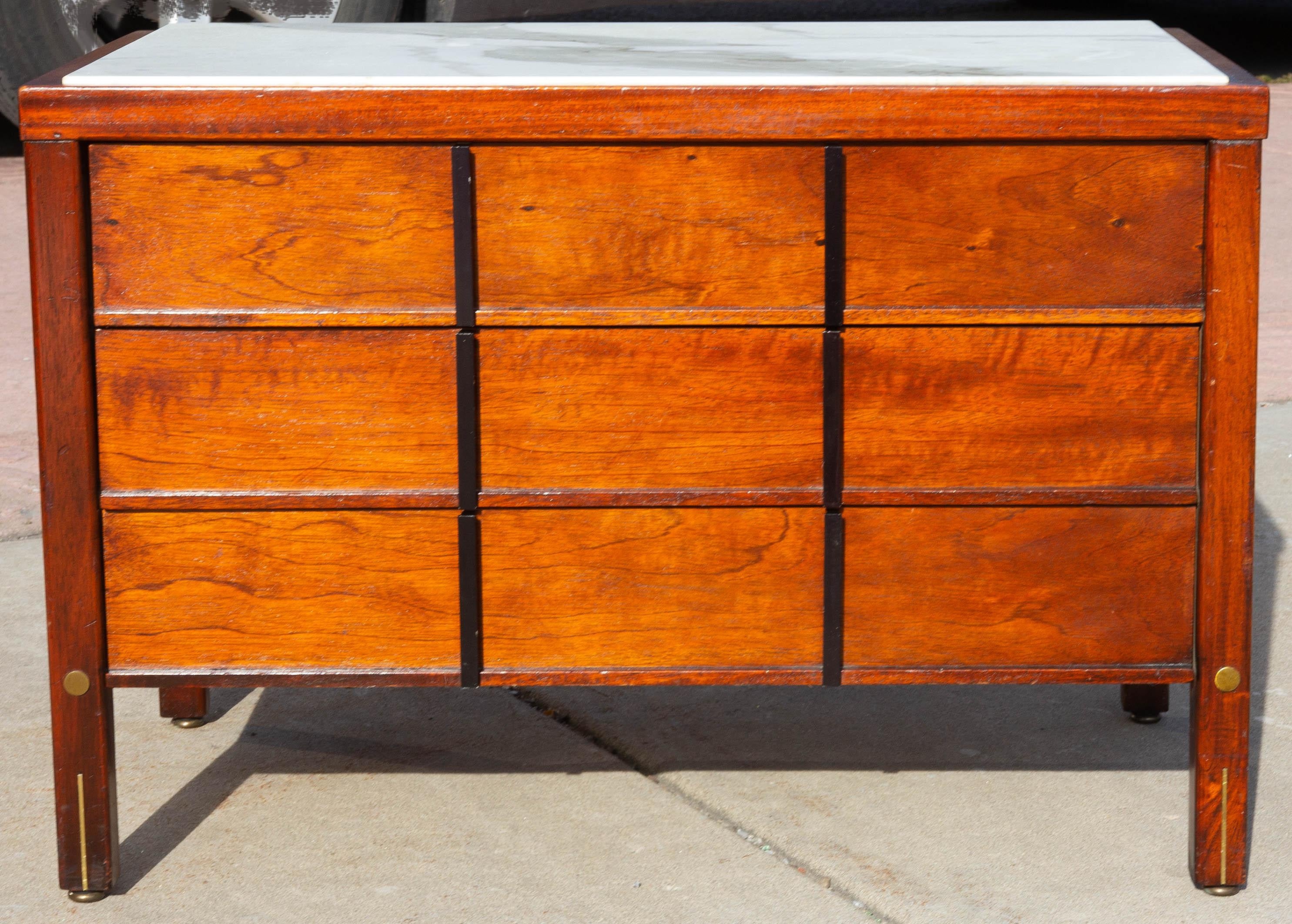 Mid-Century Modern mahogany low marble-top commode. Three drawers. Brass inlay.