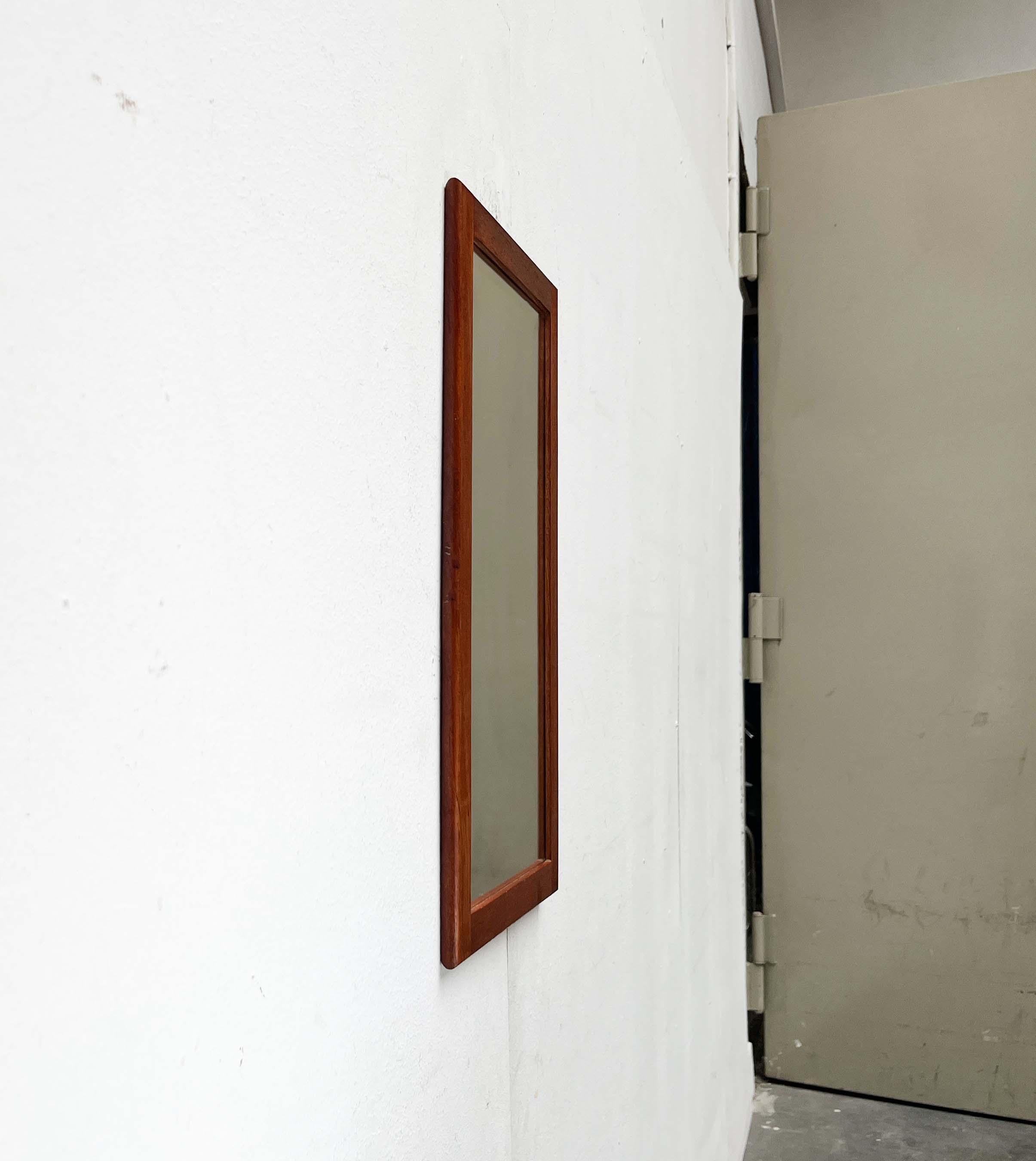 Dänischer Wandspiegel mit einem eleganten Rahmen aus massivem Teakholz.

Das sehr flache und schlichte Design des Rahmens ist auffällig. Ein weiteres einzigartiges Merkmal ist seine kompakte Größe, die den Einsatz auch in kleinen Räumen ermöglicht.