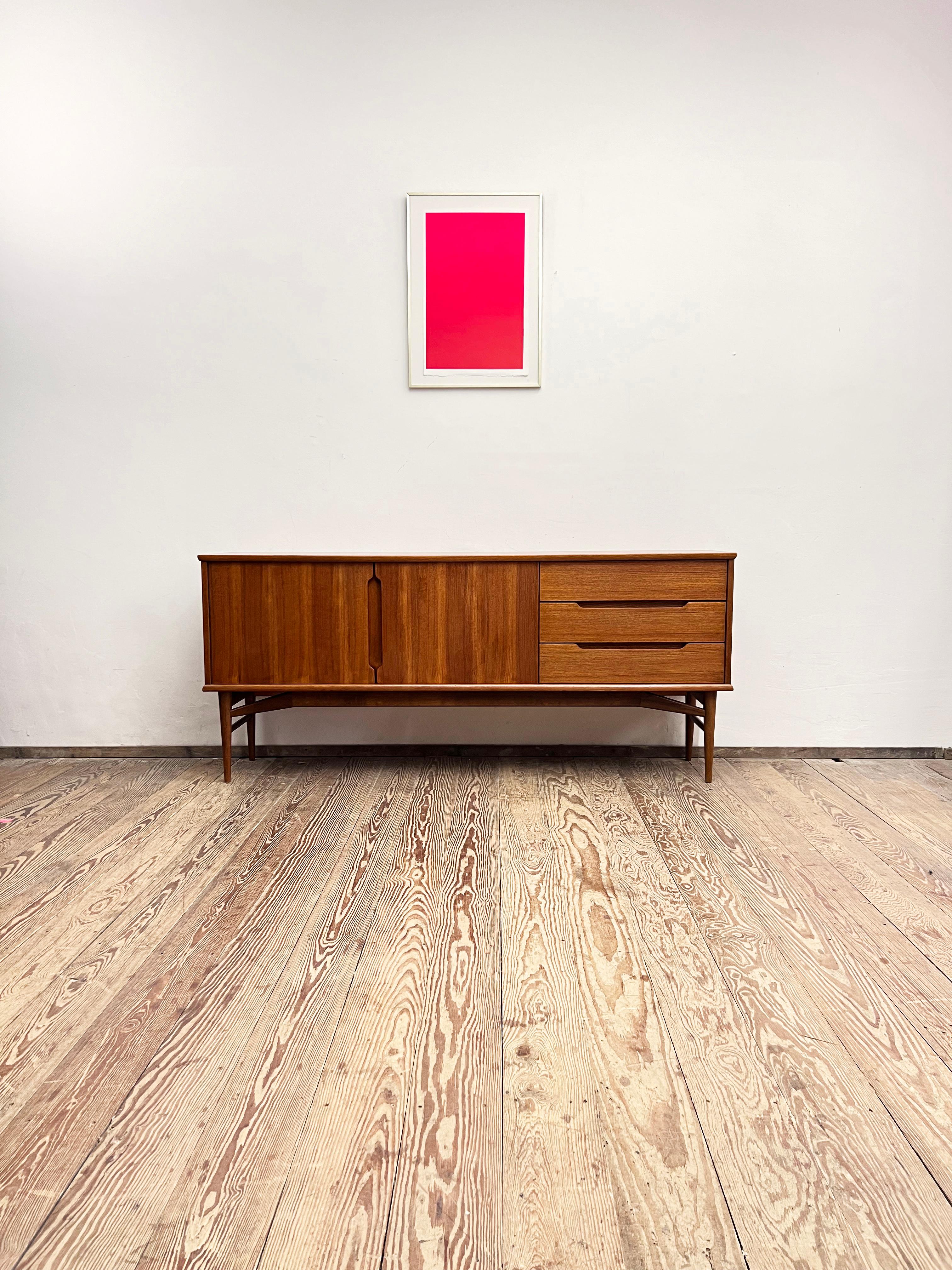 Dimensions: 188 x 43 x 82,5 cm (Width x Depth x Height)

This design sideboard or TV console was manufactured in the 1950s in Germany.

The mid-century Credenza showcases exquisite design and offers lots of storage space on tapered legs and lots of