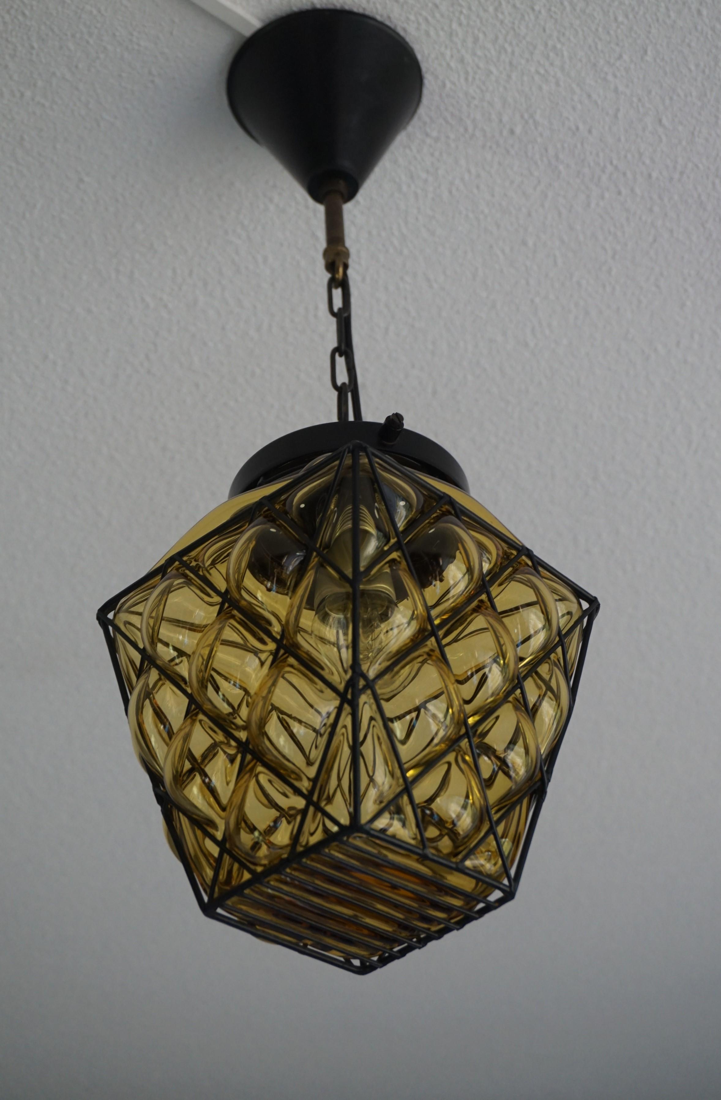 Perfect condition and wonderfully handcrafted, midcentury pendant.

This small and completely original, midcentury light fixture is ideal for usage in a small entrance, a small bedroom or a private restroom. The wonderful, amber colored glass is