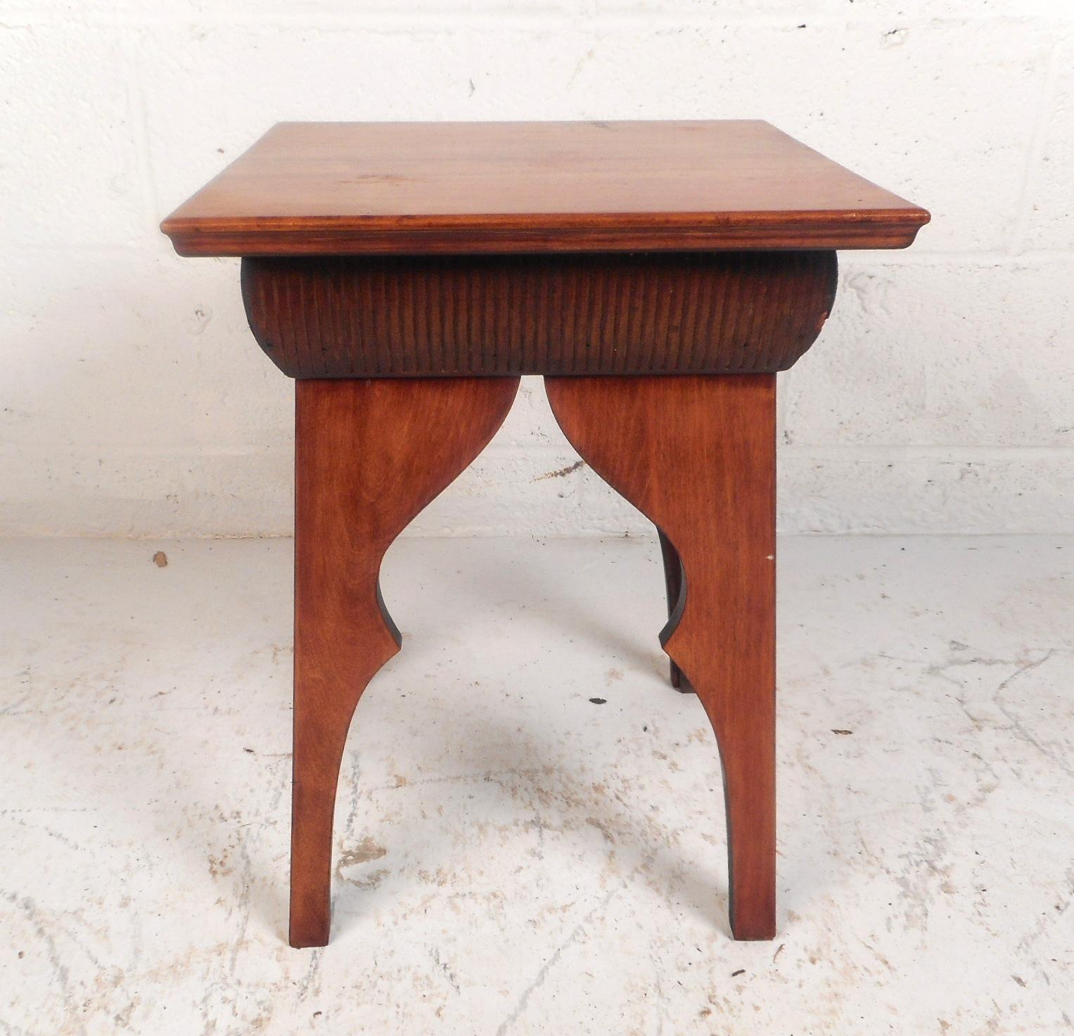 This unique vintage modern table features sculpted legs and a decorative trim underneath the square top. The stylish design and beautiful dark finish make this piece the perfect addition to any modern interior. Please confirm item location (NY or