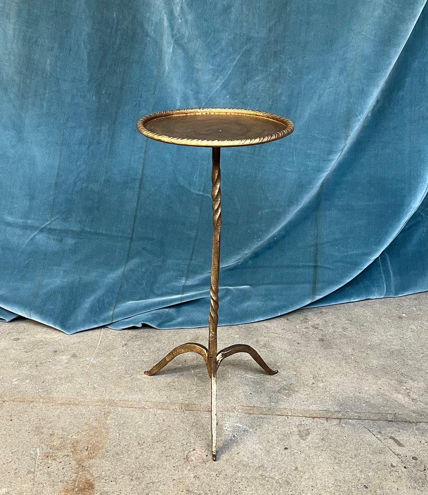 Cette petite table d'appoint unique, originaire d'Espagne, se distingue par son plateau rond entouré d'un rebord roulé, monté sur une tige torsadée ornementale. Récemment créée par des artisans accomplis utilisant des méthodes traditionnelles de