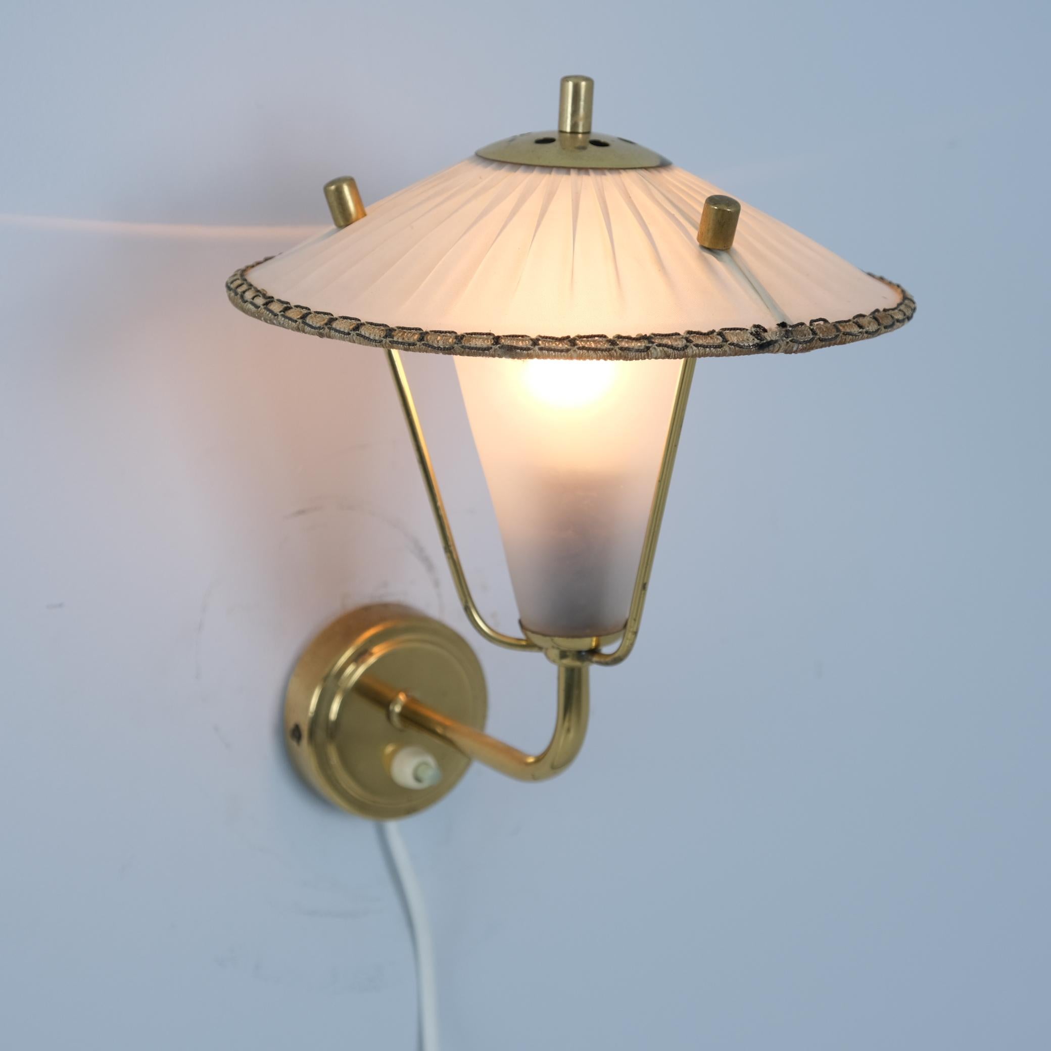 Petite applique vintage en laiton, verre et plastique enveloppé sur abat-jour fabriquée par Valinte en Finlande dans les années 1950. Le modèle de lampe est le 2335  et est le catalogue de Valinte des années 1950. La lampe est petite et a un style