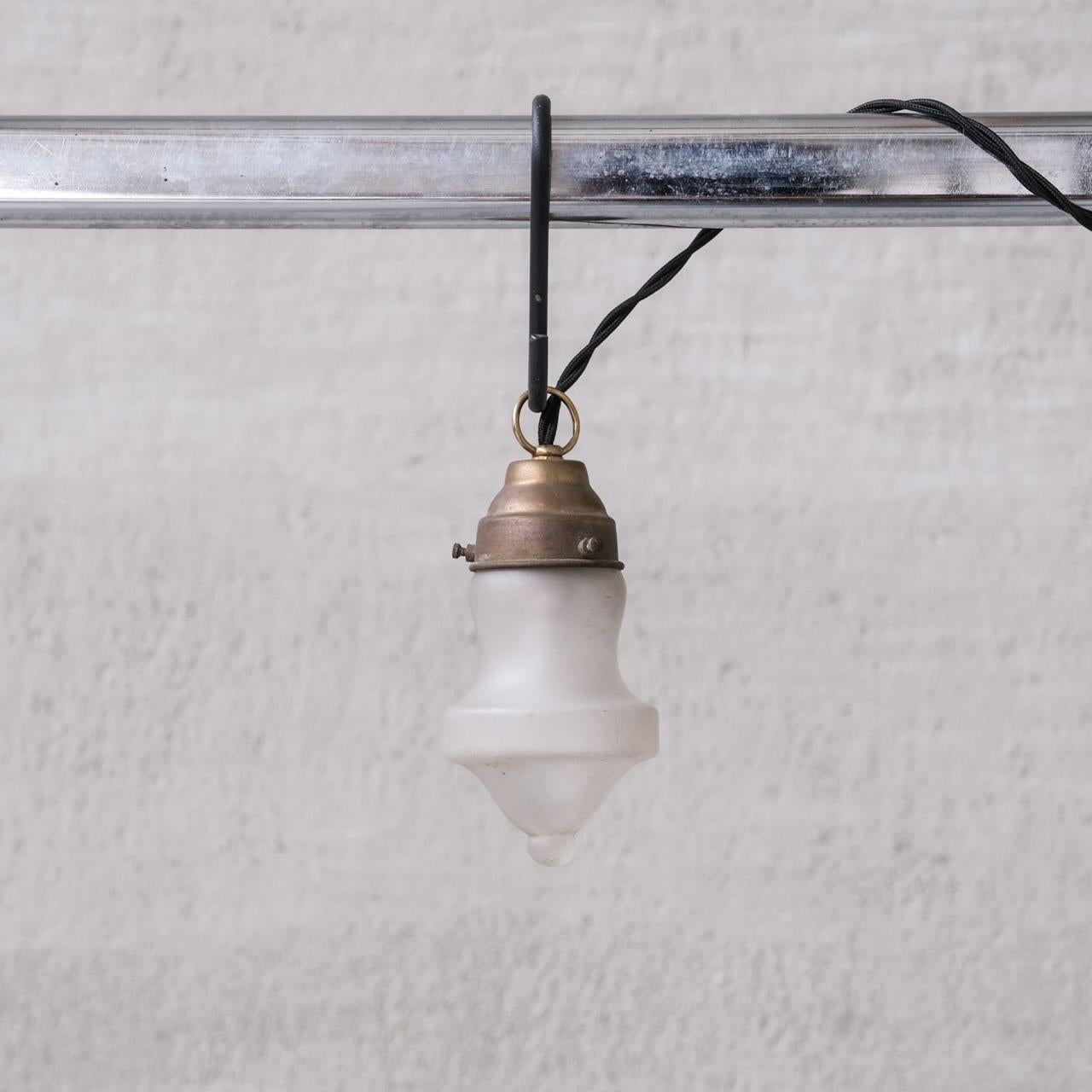 Very small pendant lights.

France, c1950s.

Naturally patinated brass galleries with opaque glass shades.

PRICED AND SOLD INDIVIDUALLY.

Re-wired and PAT tested.

No chain or ceiling rose was retained, we can recommend where to source.

Good