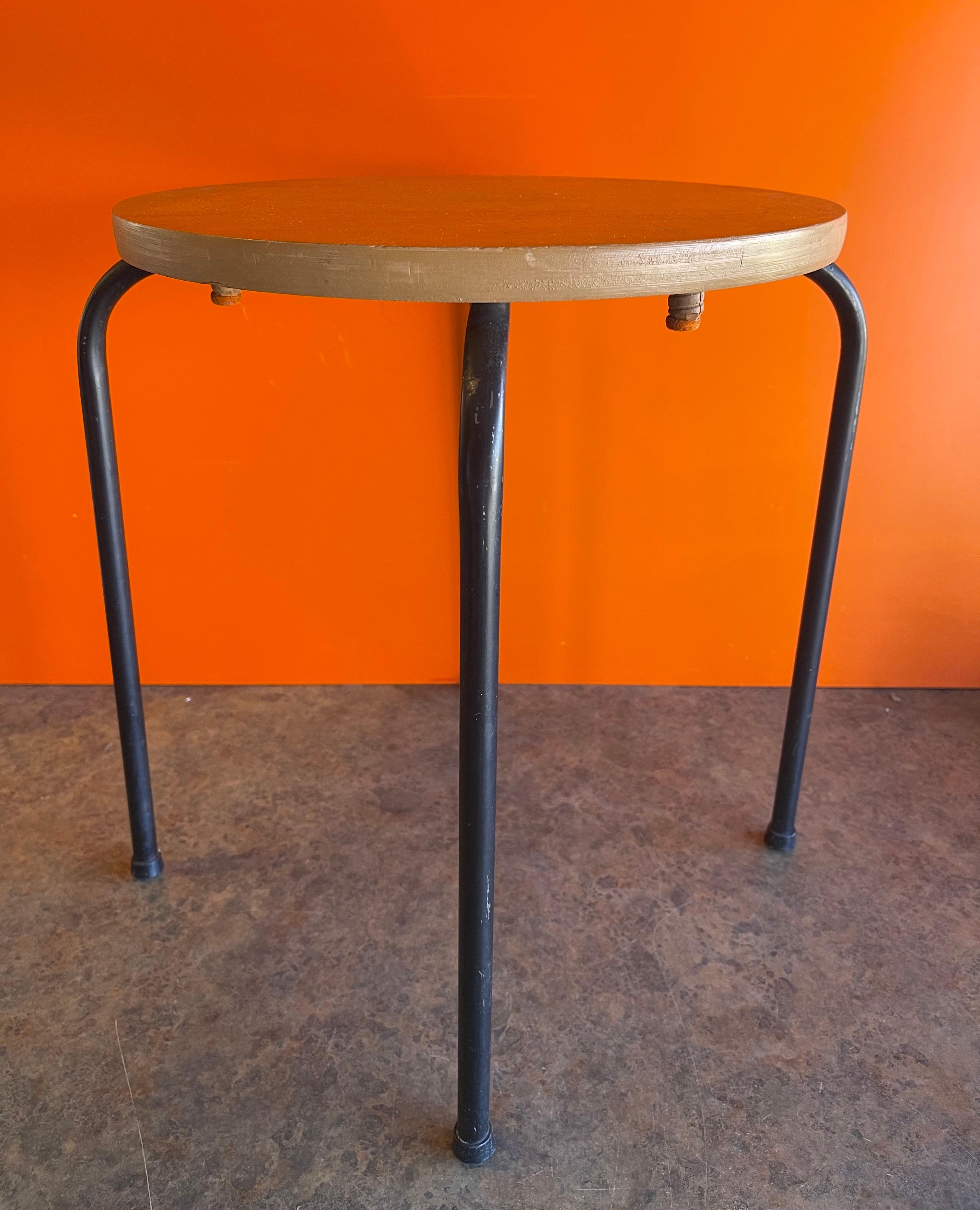 Small mid-century round maple top table with four black metal legs, circa 1960s. The table measures 17.25