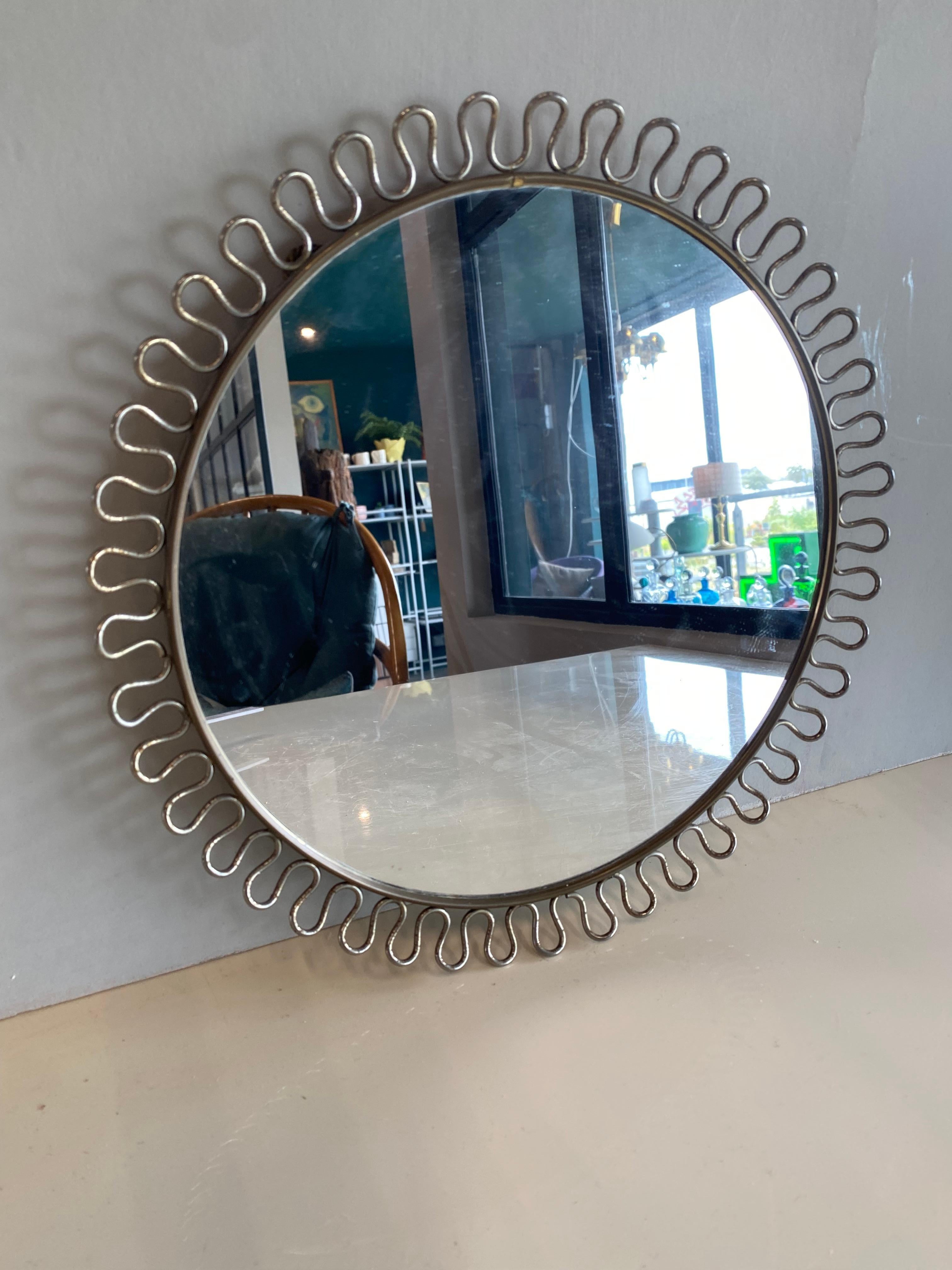 This small mid century mirror by Joseph Frank was designed and manufactured for Svenskt Tenn during the 1950s.
It is made of brass and has an original cord for hanging.
 Josef Frank was born in Austria in 1885. He was an architect, a designer,