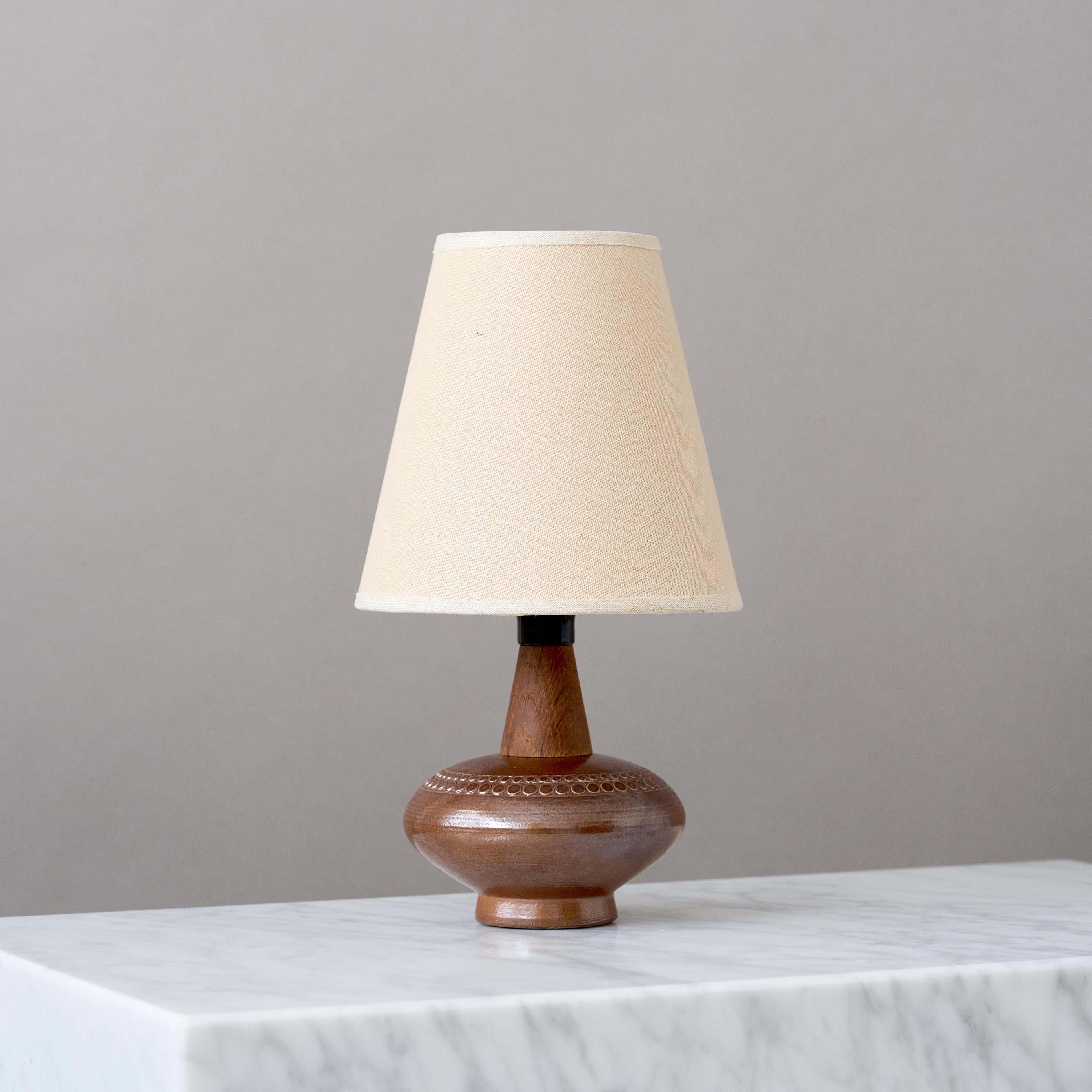 Magnifique lampe de table en grès du milieu du siècle, avec un col en bois de teck.
Fabriqué par le céramiste suédois Yngve Blixt dans son propre studio à Höganäs, en Suède, dans les années 1960.

Excellent état d'origine. 
Signé 