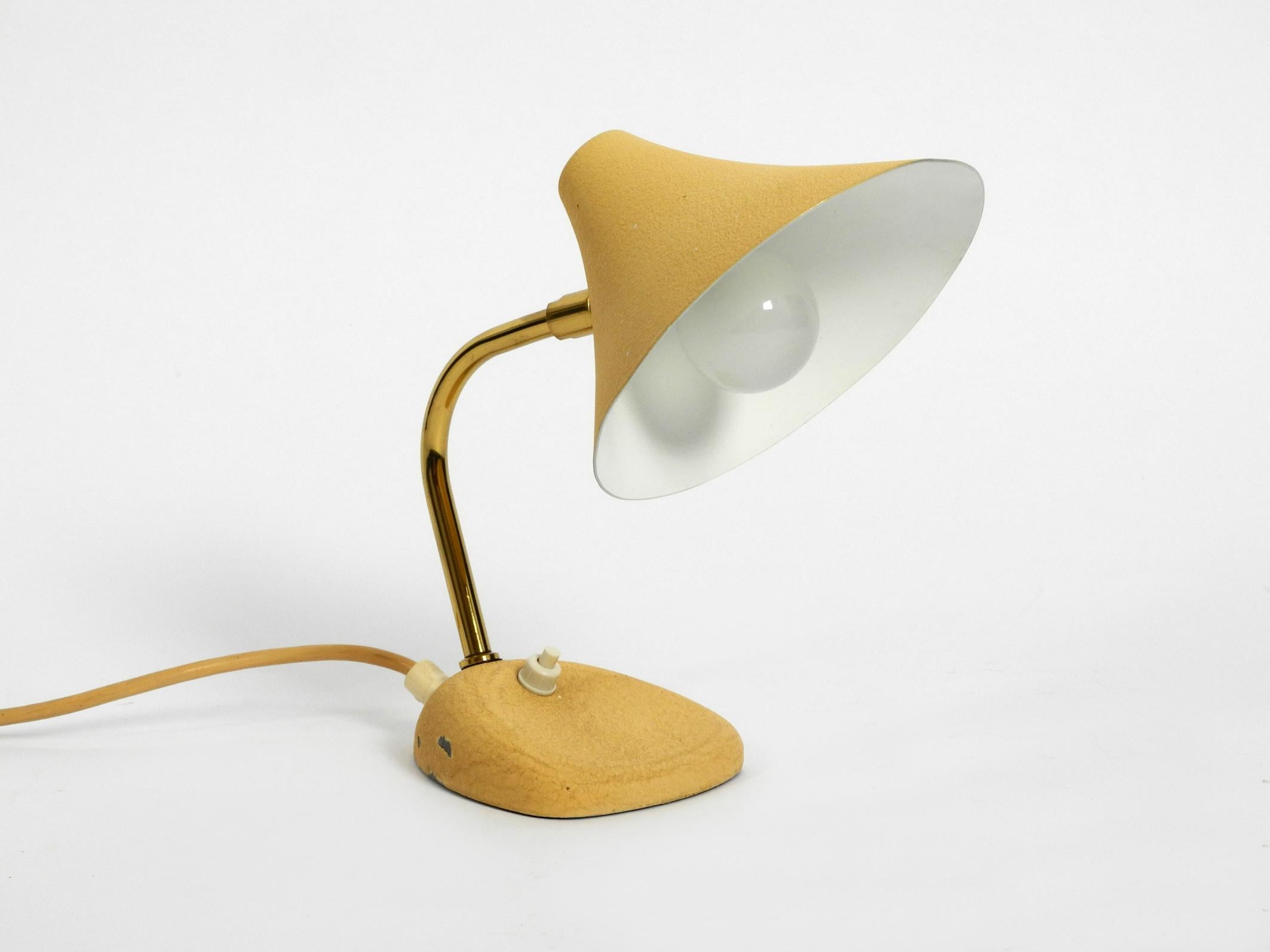Very nice little Mid-Century Modern table lamp. Made in Austria.
Great 1950s design with beige shrink paint and steplessly adjustable shade. 
Good vintage condition without damage.
On one side two paint abrasions on the foot.
Heavy foot for