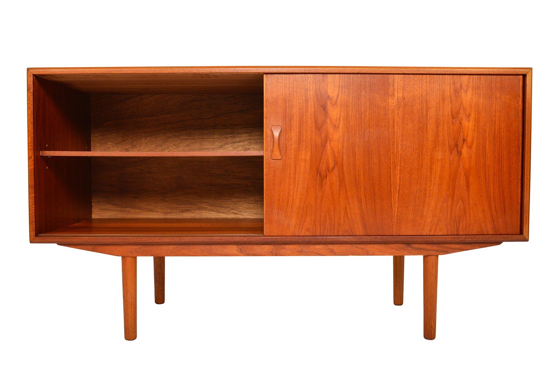Efficiently compact, this Danish modern teak credenza was manufactured by Clausen and Søn in the 1960s. A large sliding door opens to reveal a single bay with an adjustable shelf. Four drawers with complimentary pulls sit to the right for additional