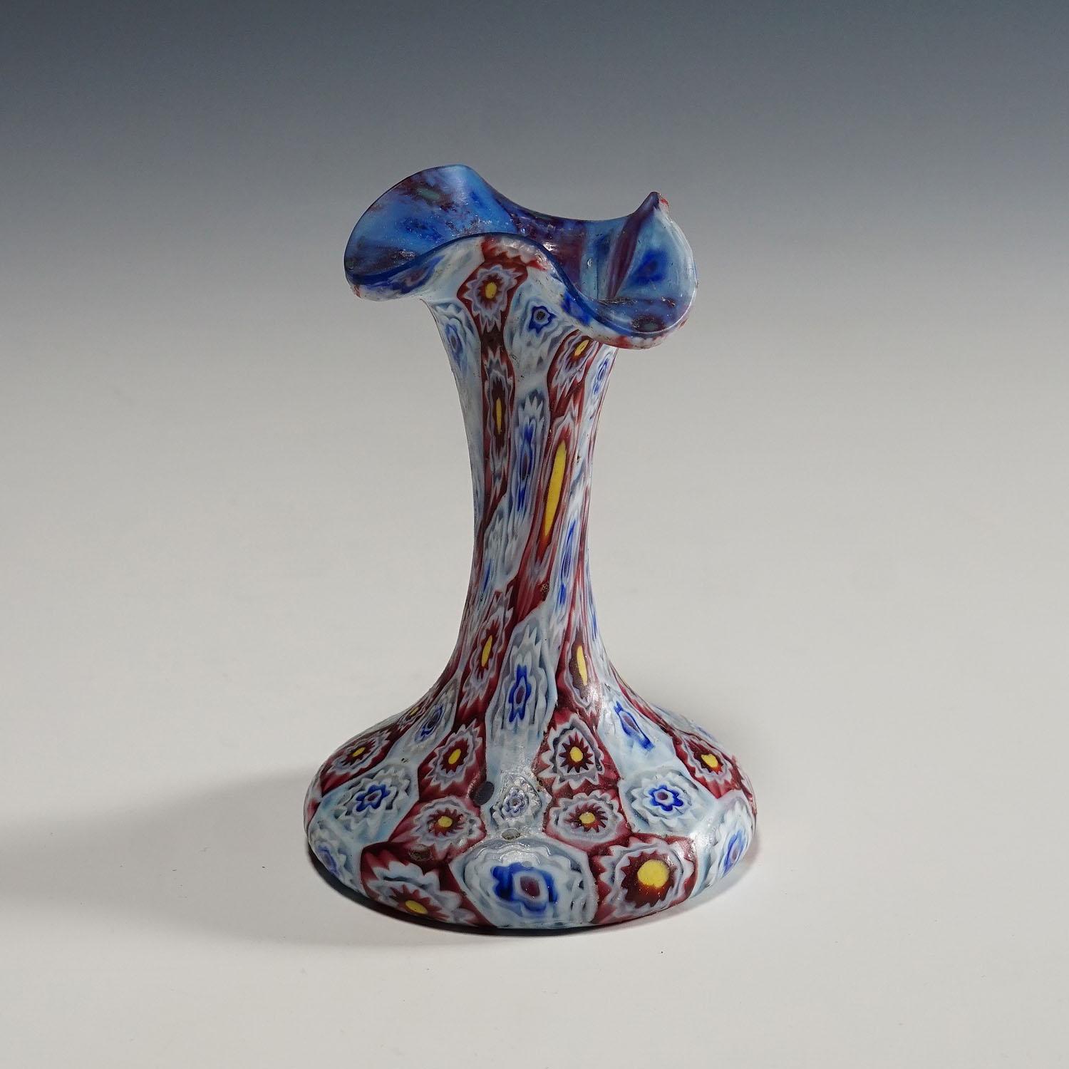 Small Millefiori vase in blue, red and white, Fratelli Toso Murano 1910.

A nice Millefiori murrine glass vase with undulating rim. Manufactured by Vetreria Fratelli Toso, Murano around 1910. Transparent blue glass with melted polychrome murrines in