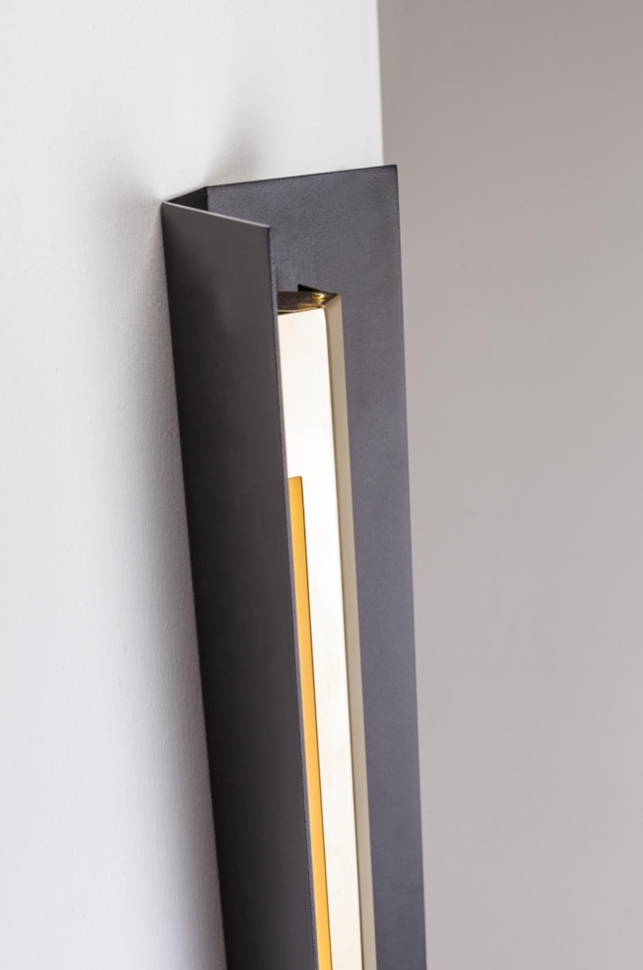 Small Misalliance Ex jet black wall light by Lexavala.
Dimensions: D 16 x W 70 x H 8 cm
Materials: powder coated shade with details made of brass or stainless steel.

There are two lenghts of socket covers, extending over the LED. Two short are
