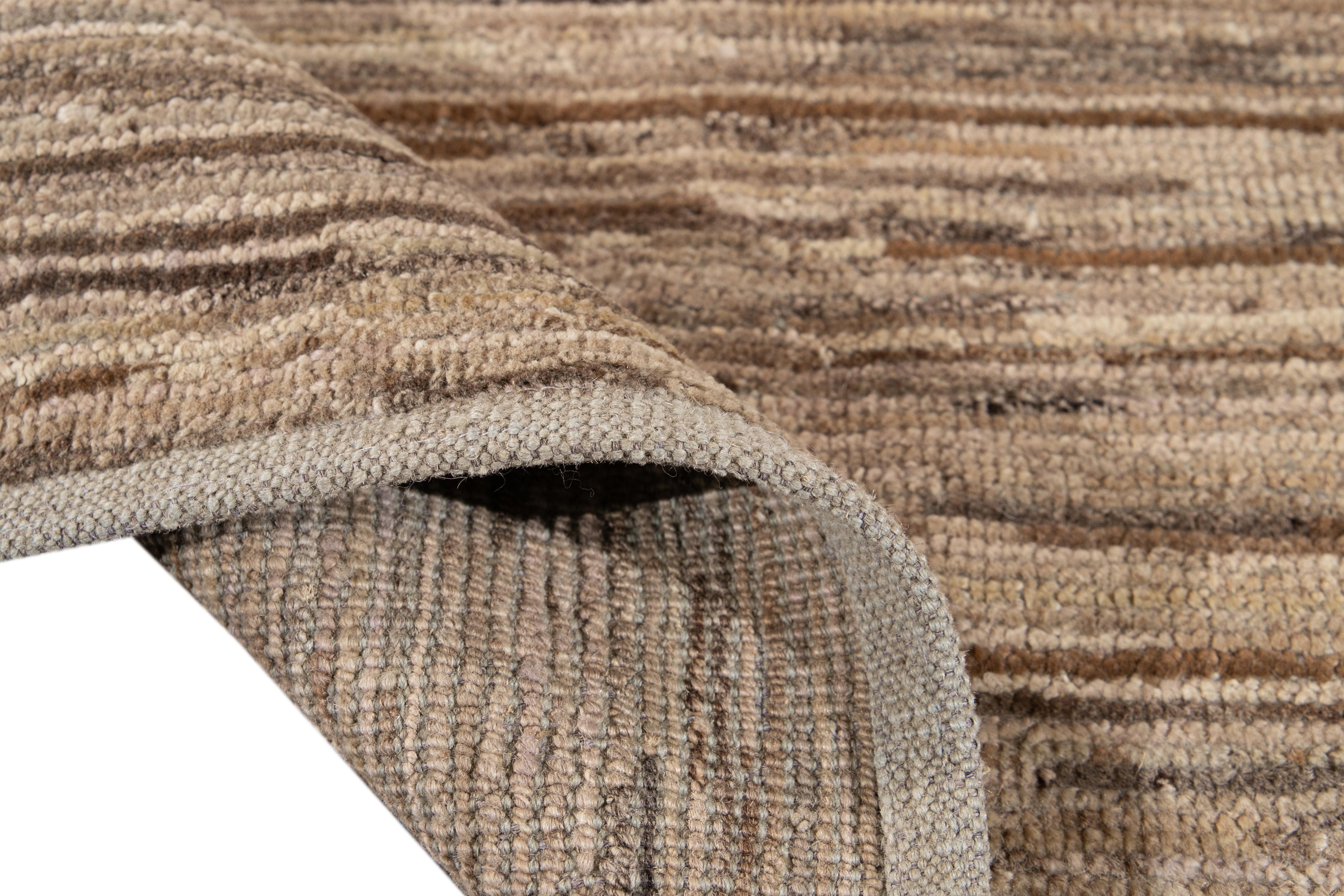 Preciosa alfombra de lana anudada a mano de estilo marroquí con campo beige. Esta alfombra tiene toques marrones en un precioso diseño geométrico abstracto.

Esta alfombra mide 3'8