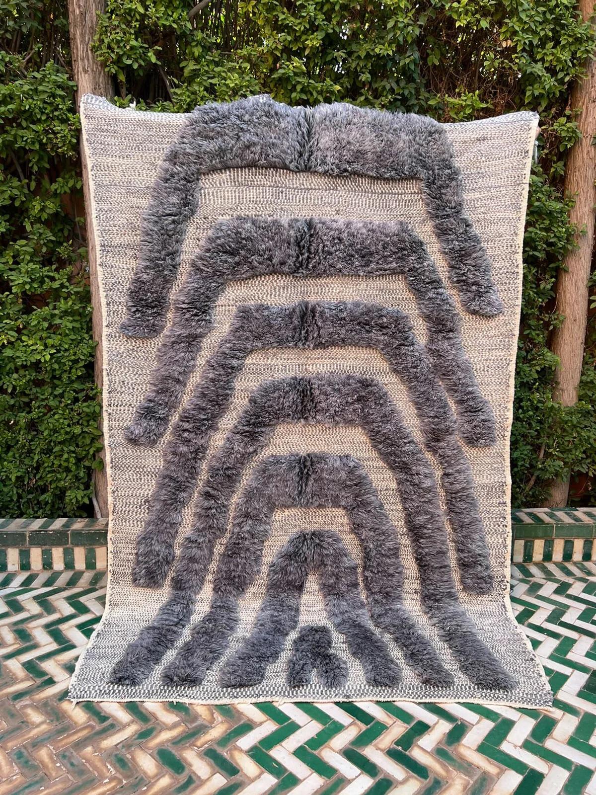 Esta pequeña alfombra marroquí tejida a mano fue fabricada en un telar tradicional por hábiles artesanos de la cordillera del Atlas. Las técnicas mixtas de tejido hacen que esta pieza sea especial, ya que presenta una base de tejido plano o kilim y