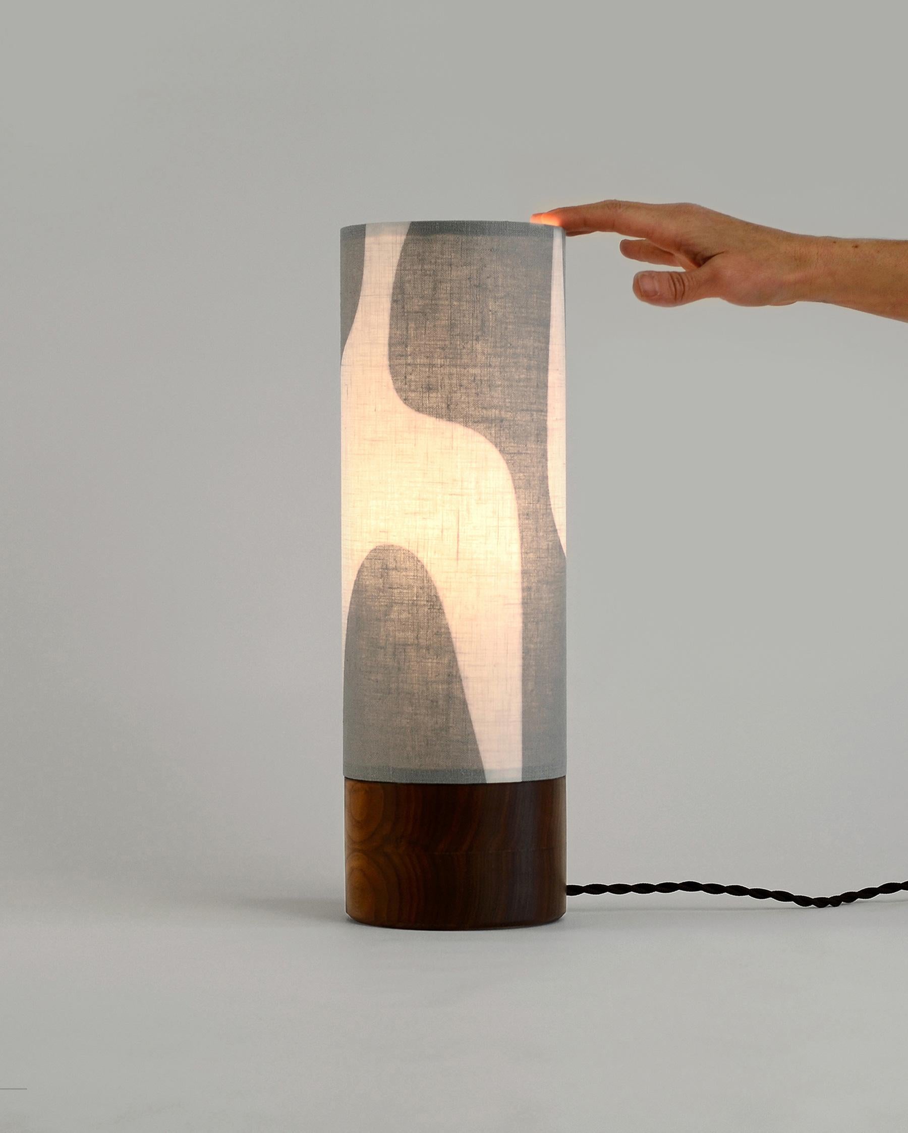 De style moderne, cette lampe de table combine des formes épurées et curvilignes pour créer une pièce unique.  Notre Collection Luma joue avec des formes simples, explorant l'espace positif et négatif pour créer un design d'abat-jour unique et