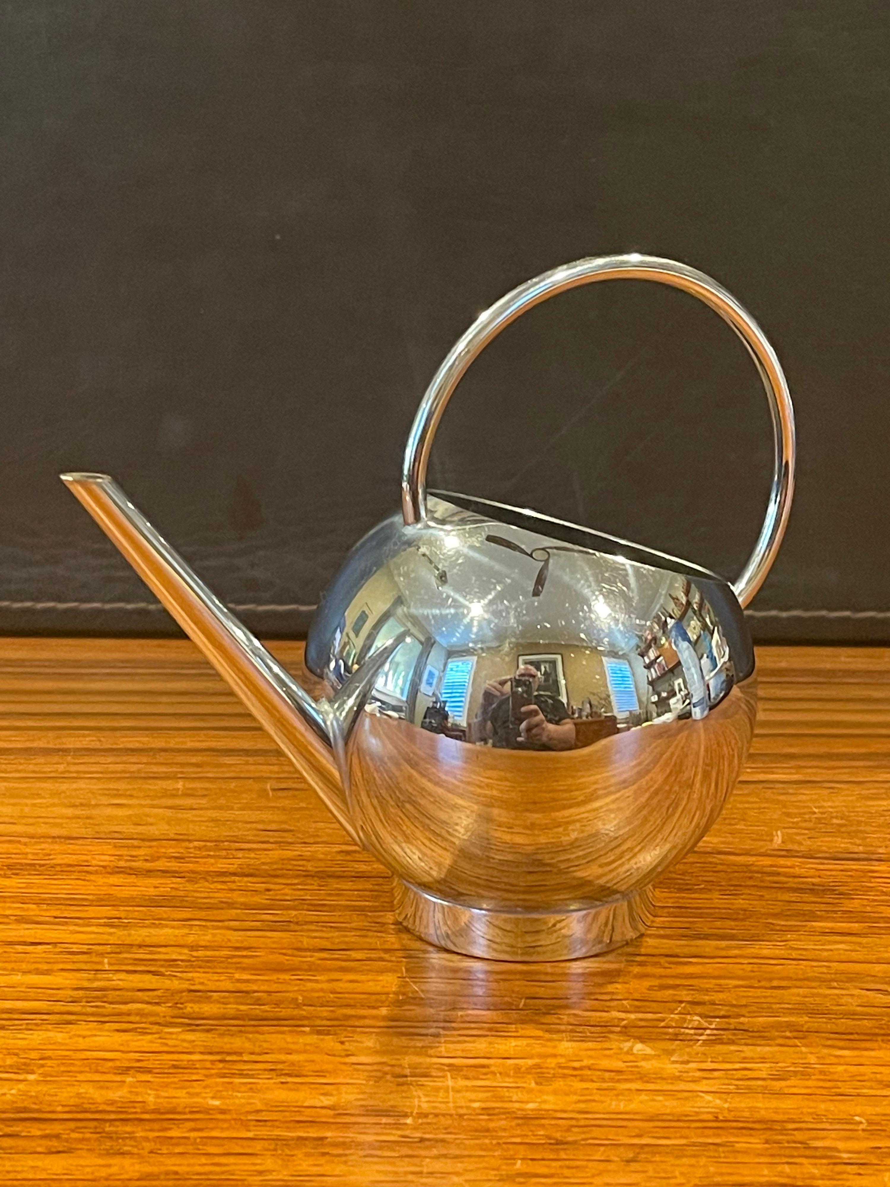 A very nice small chrome pitcher by Russel Wright for Chase & Co., circa 1940s. The modernist stainless steel design features a very sleek rounded handle and would be great for syrup, cream or watering a small plant. The piece is in very good