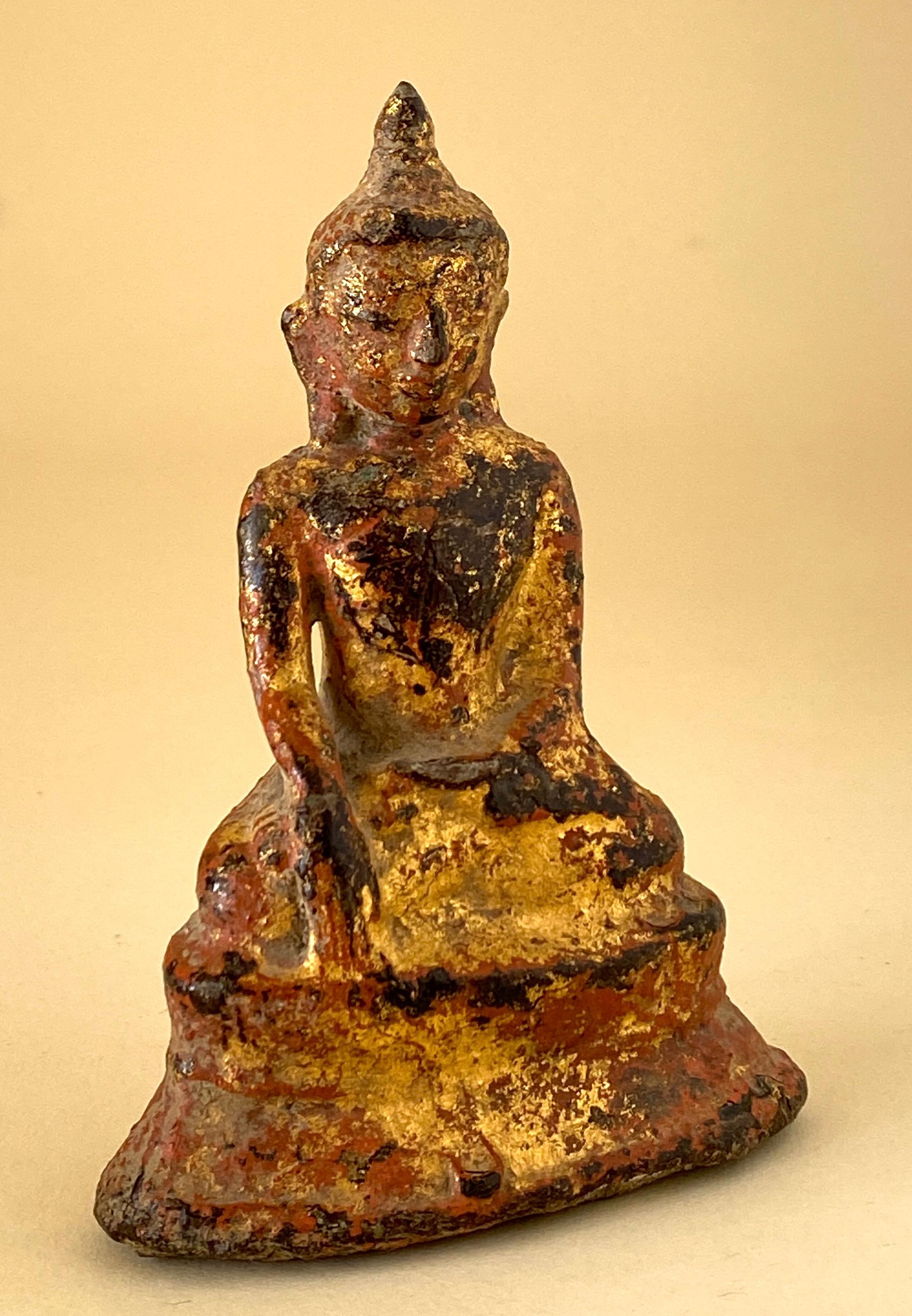 Store closing March 31. A small but monumental bronze with layered patina of gilt and paint or lacquer. Some red color appears on the piece, not sure what it is, maybe a paint or lacquer. The Buddha seated in Vajrasana with hands in Bhumisparsha