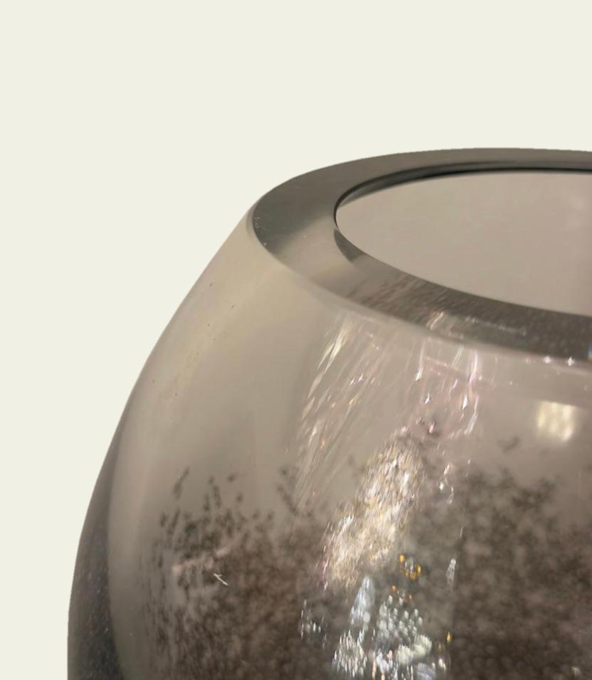 Mit ihrer rauchigen, grauen Farbe und der sprudelnden Textur bringt diese Glasvase die Eleganz venezianischer Handwerkskunst in jeden Raum. Diese kurze Vase wurde in Murano in der traditionellen Pulegoso-Technik mundgeblasen und weist eine dichte