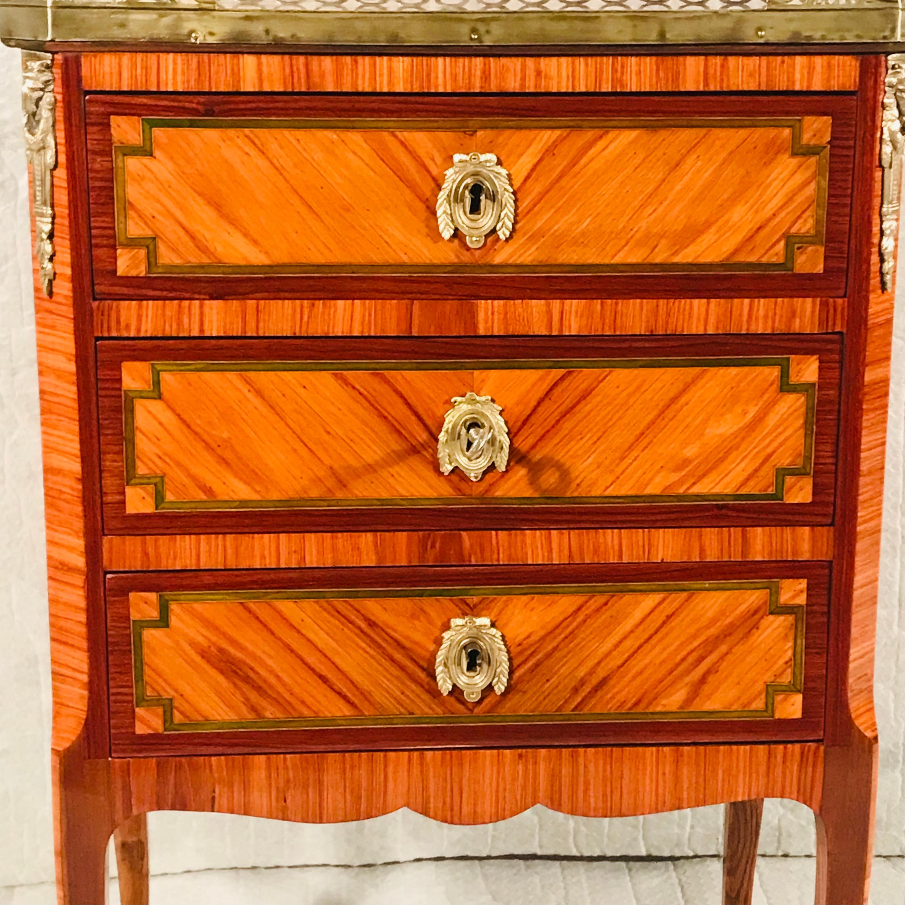 Cette exquise petite commode Napoléon III repose sur quatre pieds incurvés. Il comporte trois tiroirs. Il est décoré d'un magnifique placage de bois de rose et est orné de ferrures en bronze. En outre, il est doté d'un plateau en marbre encadré par