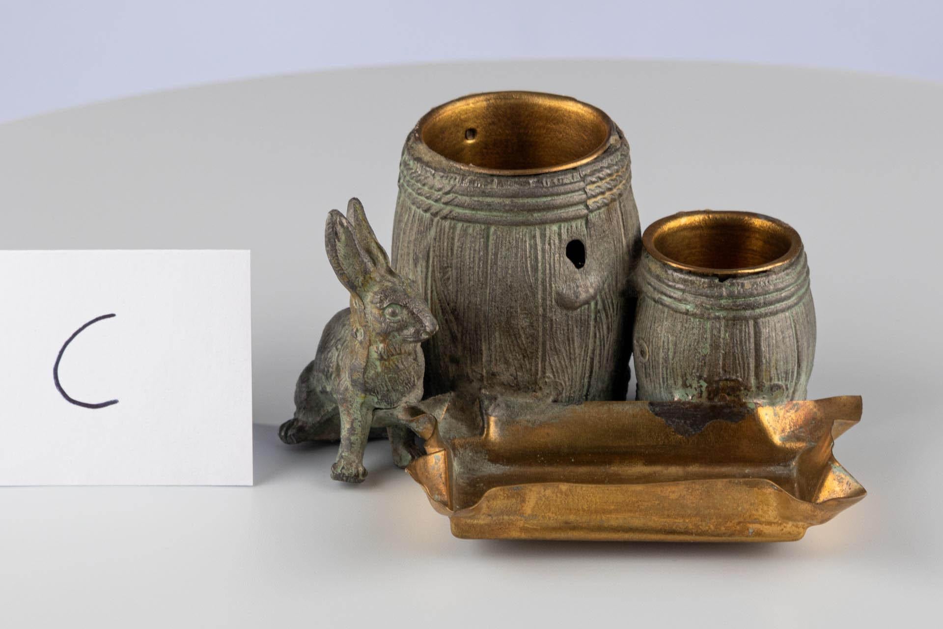 Desk Set with Hare and Barrels

Origin: Probably Germany or France
Material: Patinated and partially gilt bronze
Date: Late 19th century (c. 1880–1900)

Dimensions:
H × W × D: approx. 7.0 × 10.0 × 10.0 cm

Description:
Small desk set made of