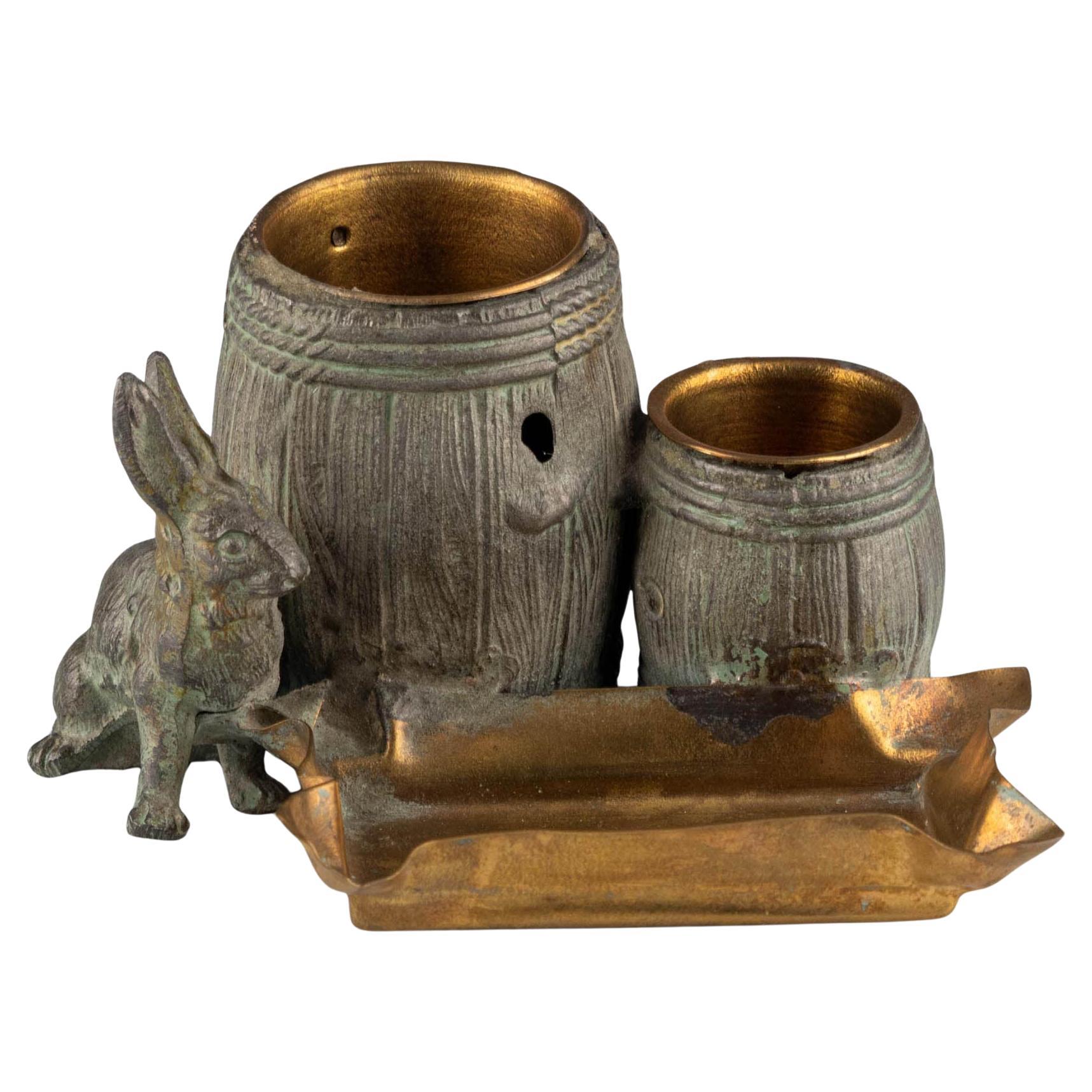 Small naturalistic desk set with rabbit and barrels made of patinated metal For Sale
