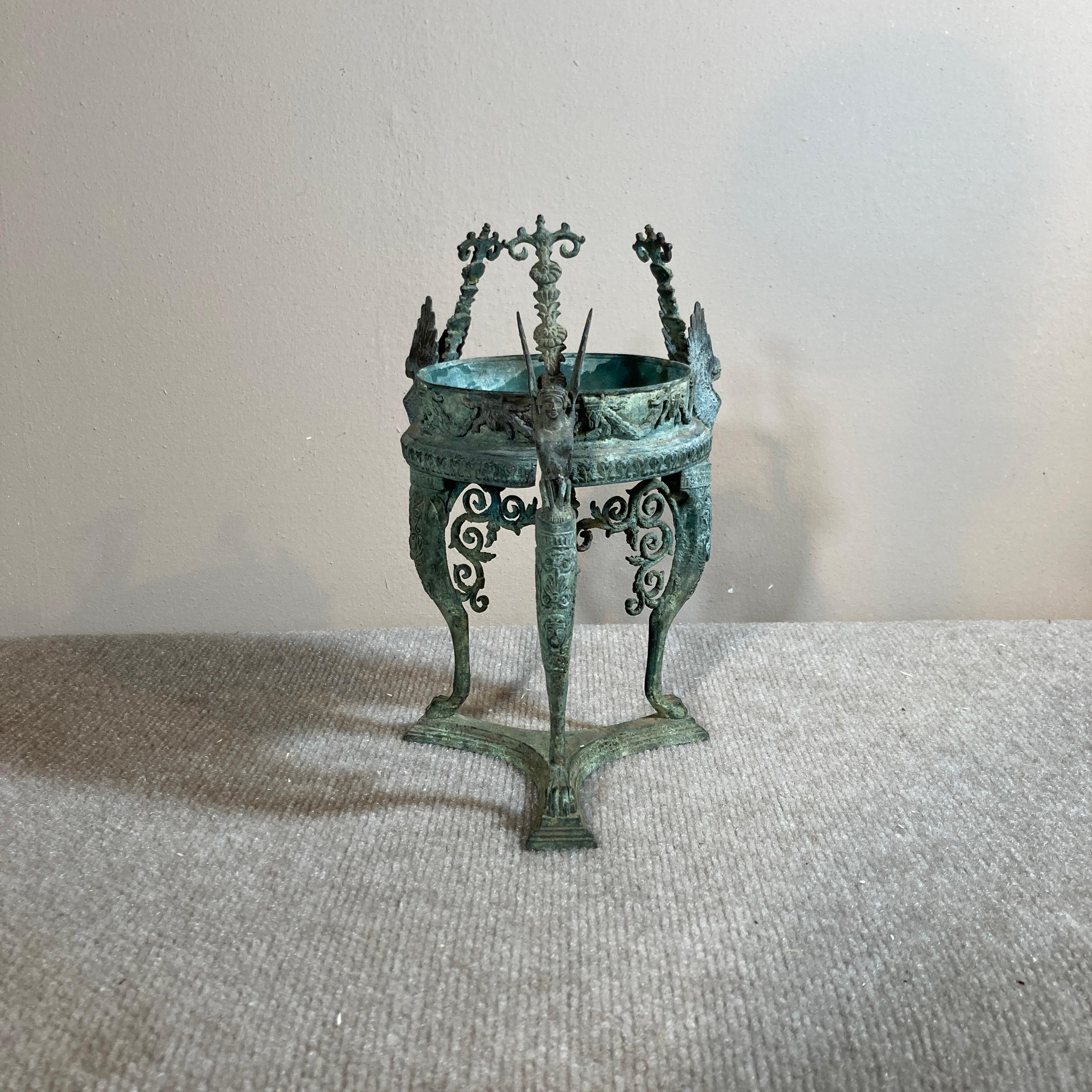 A small grand tour bronze plant holder form around 1900, in the form of an ancient Roman gueridon, in the best verdigris surface. The cast detail, including swags and jabots, caryatids, masks and anthemia, is iconic for the era, and it is of very