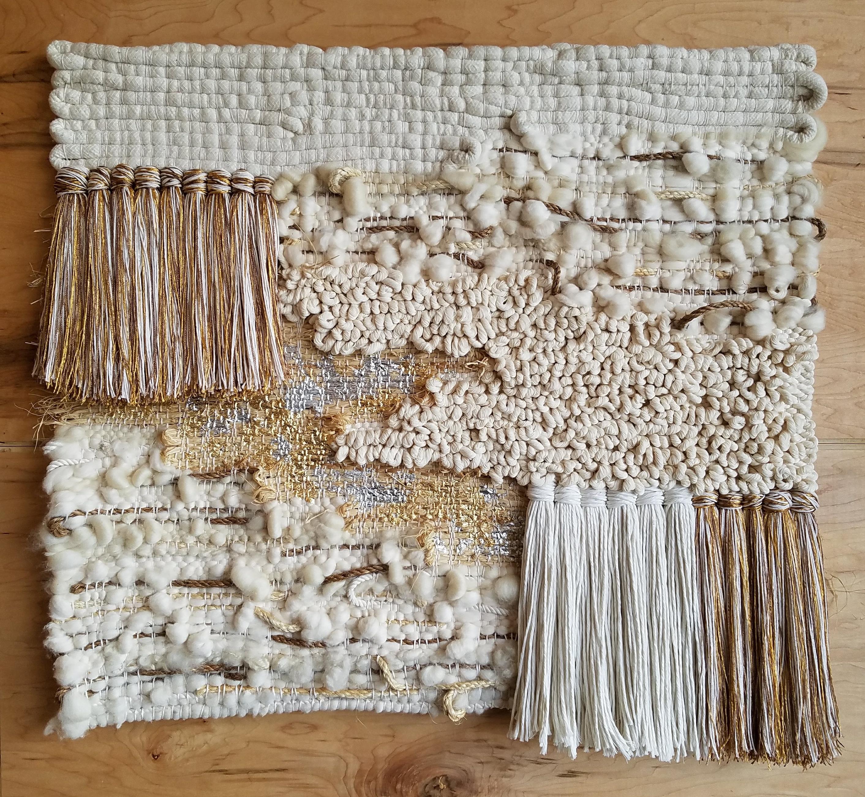 Handwoven, tapestry style, wall hanging by Janelle Pietrzak of All Roads. Neutral colors like cream, tan and brown are mixed with silver and gold metallics and various types of ropes and natural fibers are used in this textile. Gold/silver leafing