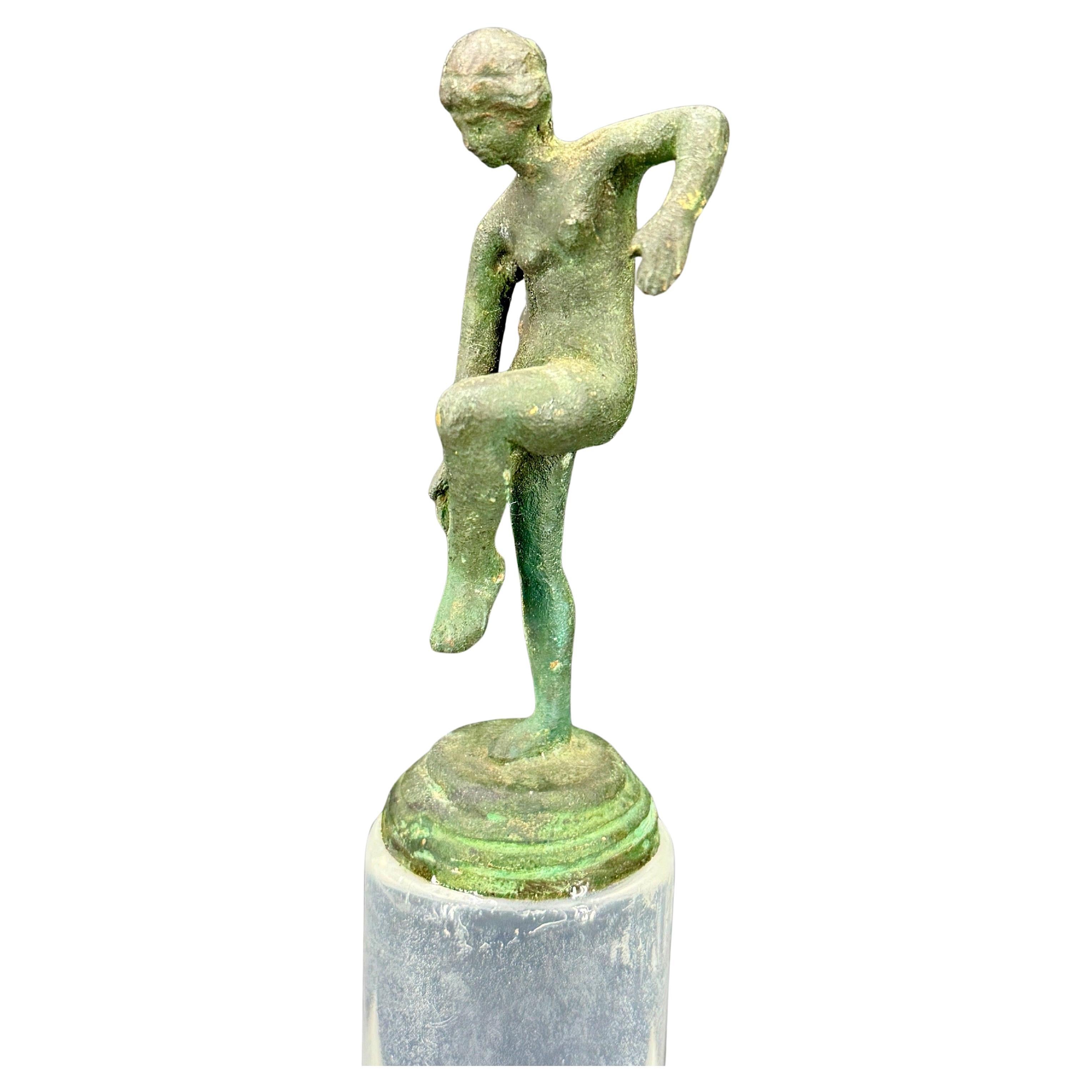 Encantadora figura de mujer posando. Esta escultura de bronce sobre una base de lucite acentuará tu hogar sobre una estantería, una consola o una mesa de centro.
