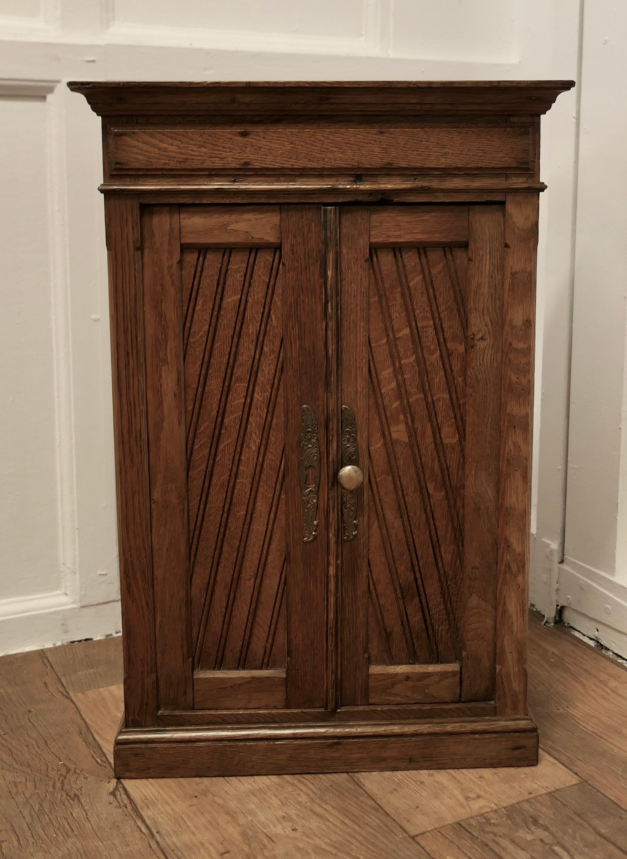 Small Oak 2 Door Cupboard 

This is an unusual piece, the cupboard stands on a small plinth and has diagonal carving to the door panels 
The cupboard has 2 doors and shelves inside, it is quite sound with a good patina
The cupboard is 24” high