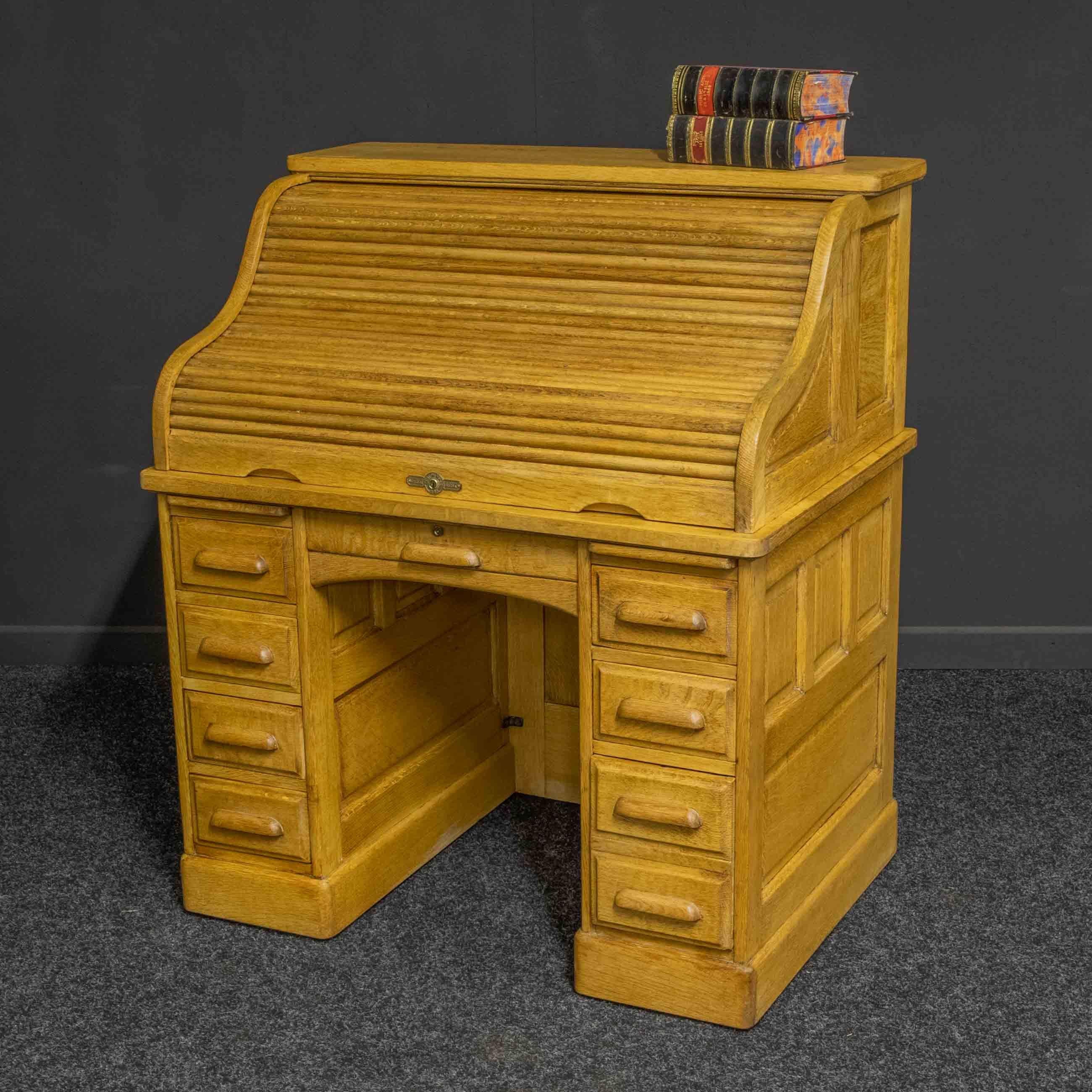 A small and attractive American roll top desk made by the 'Derby' company based in Boston. Unusual to find one in a natural oak finish and wax polished and in very good condition. When the roll is closed all the side drawers automatically lock. This