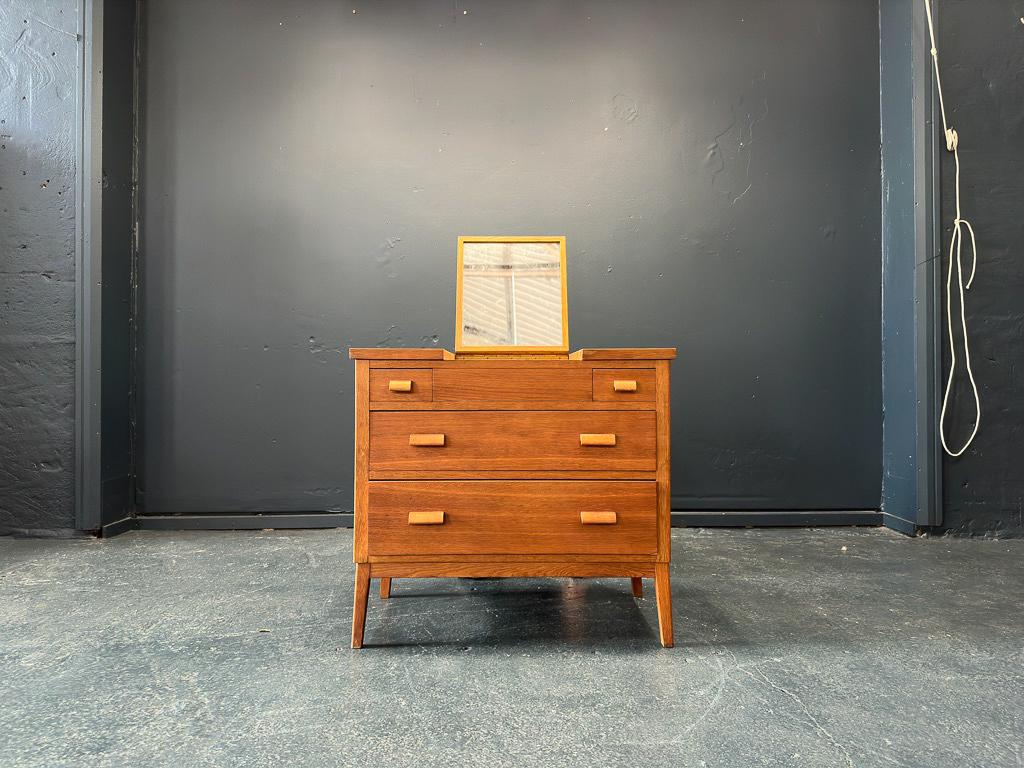 This compact oak vanity utilises the natural oak wood through the strong lines and robust structure of the piece. The vanity boasts two deep drawers, with two slim drawers on either side of the hidden mirror and chunky solid wood curved handles.